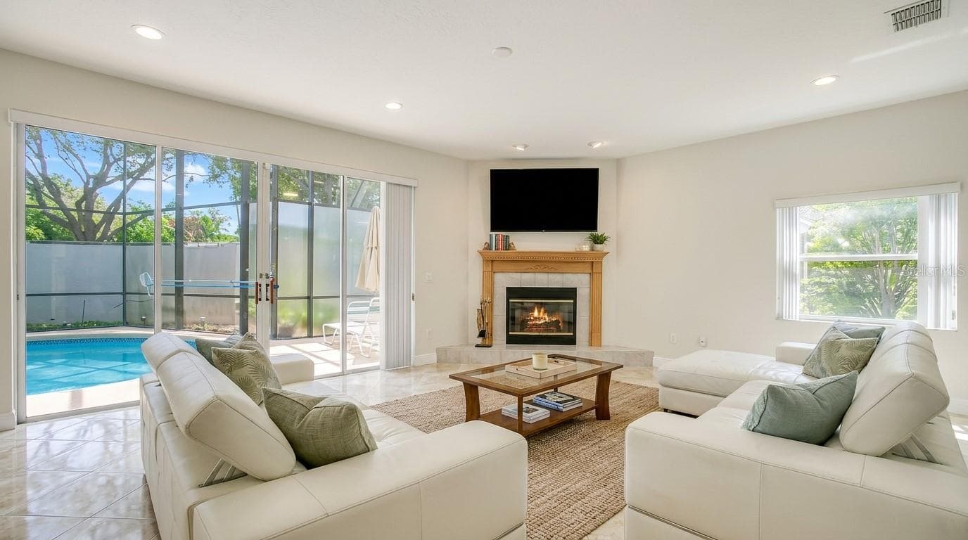 Stunning living room with an open view overlooking the backyard and private pool. - 7866 BARDMOOR HILL CIR, ORLANDO