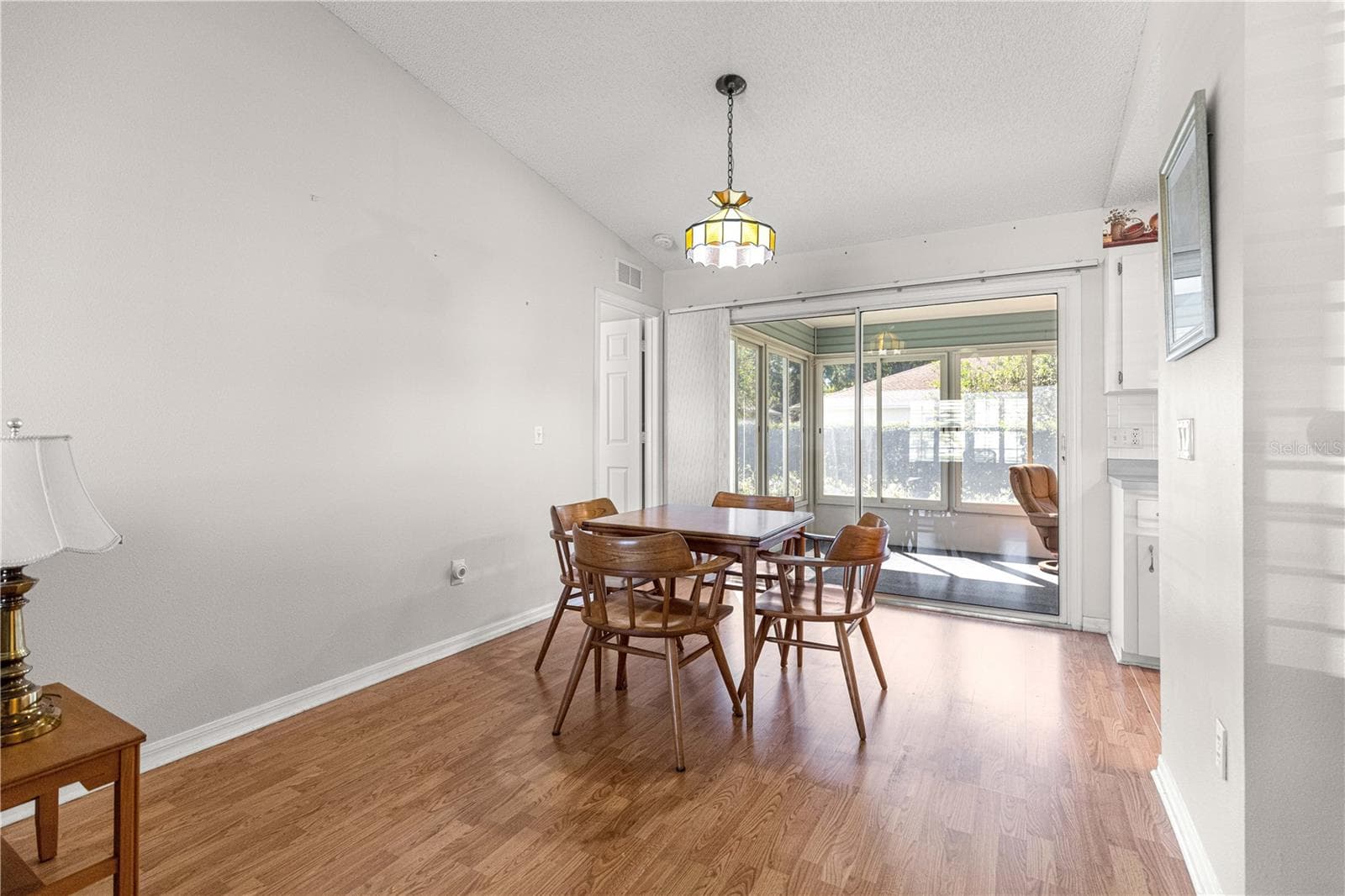 Dining area with glass sliders doors opening up into the Encl Florida Room - 6164 SW 84 LN, OCALA