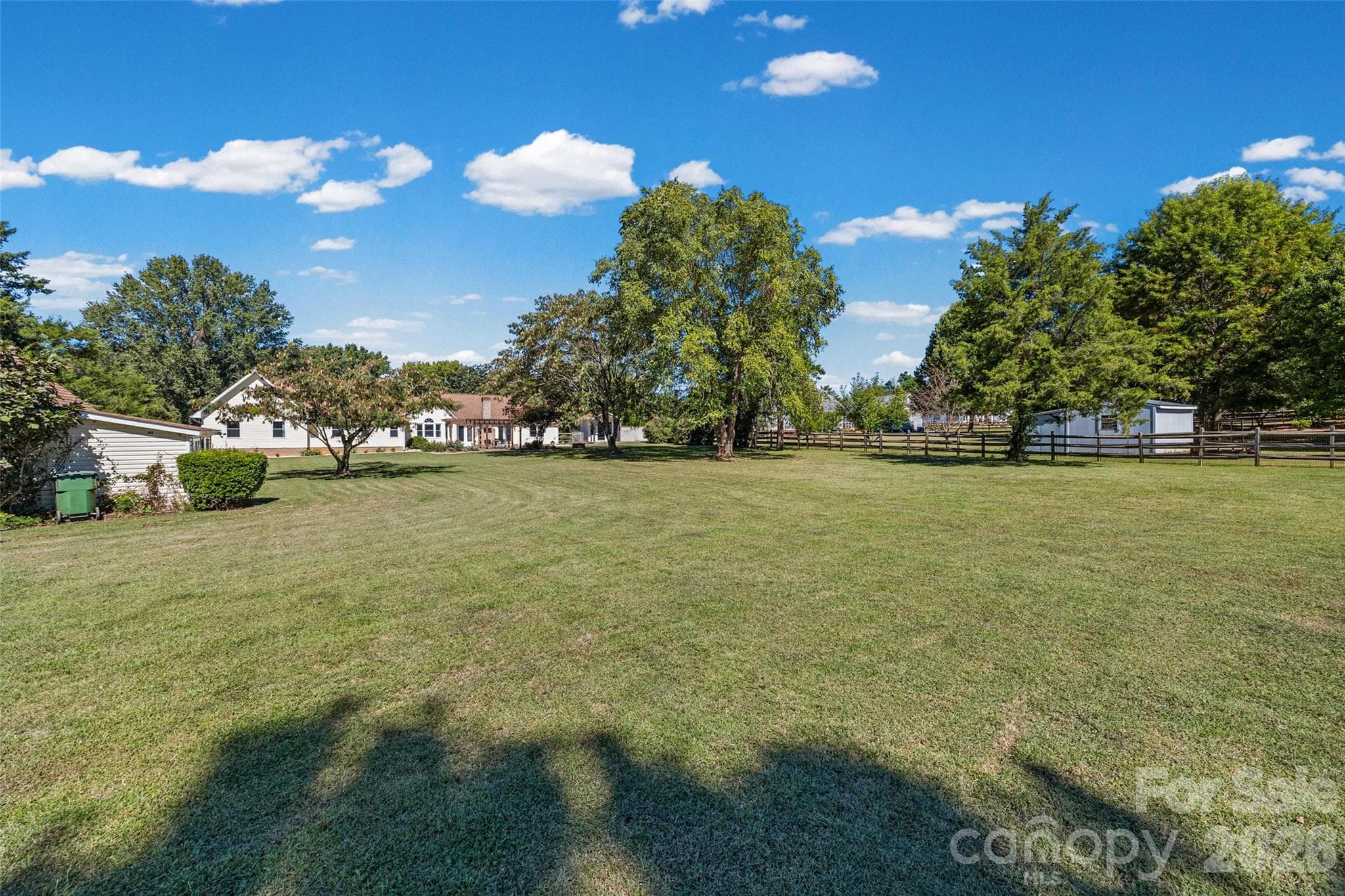 View from back of property line to the back of the house- large shed on the left  and small shed close to house on the right--large flat and meticulously maintained - 3117 Monte Drive, Monroe