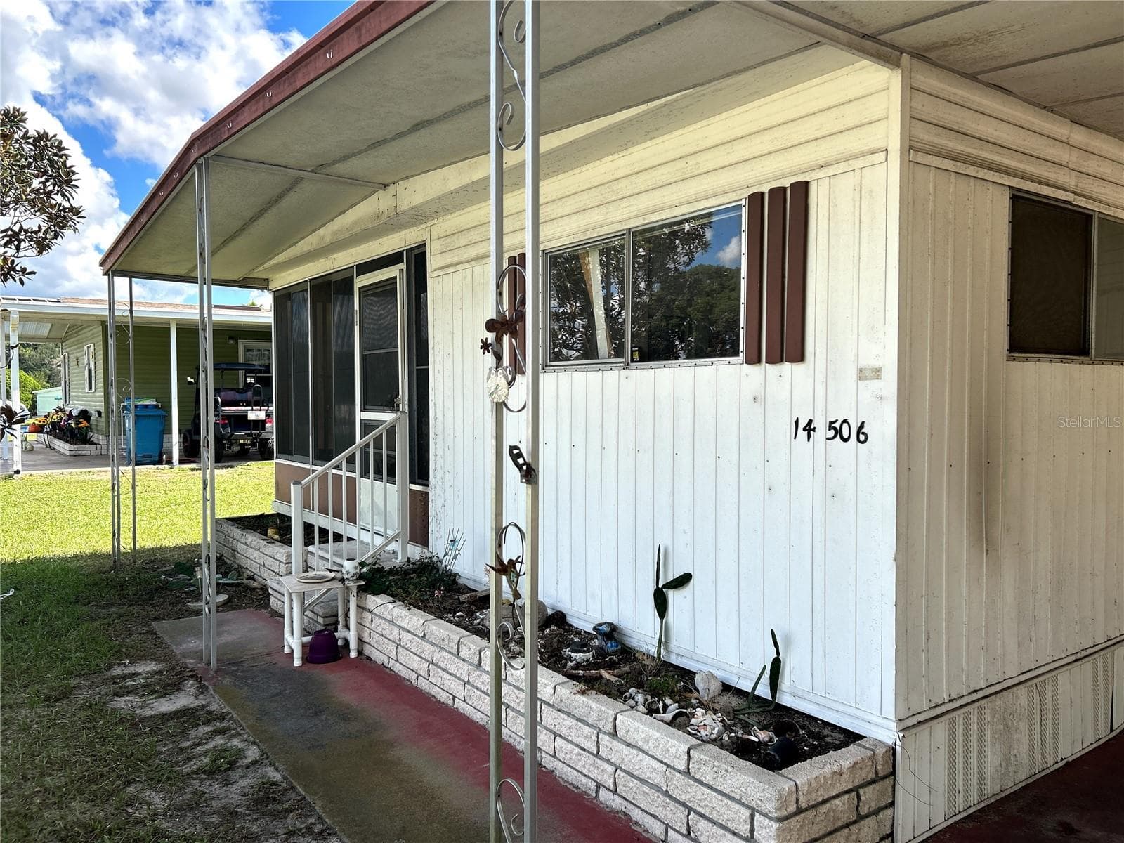 Front view of sidewalk and covered porch area to covered carport. - 14506 DEHAVEN AVE, BROOKSVILLE