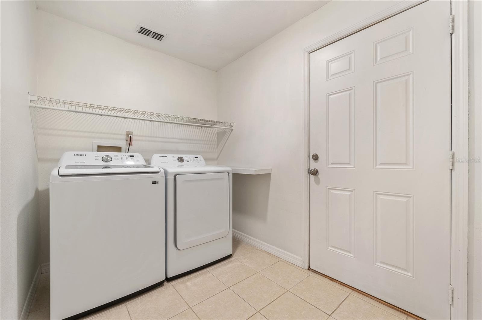 Laundry room with included washer and dryer leads out to 2 car garage. - 2040 E TRIANGLE DR, LONGWOOD