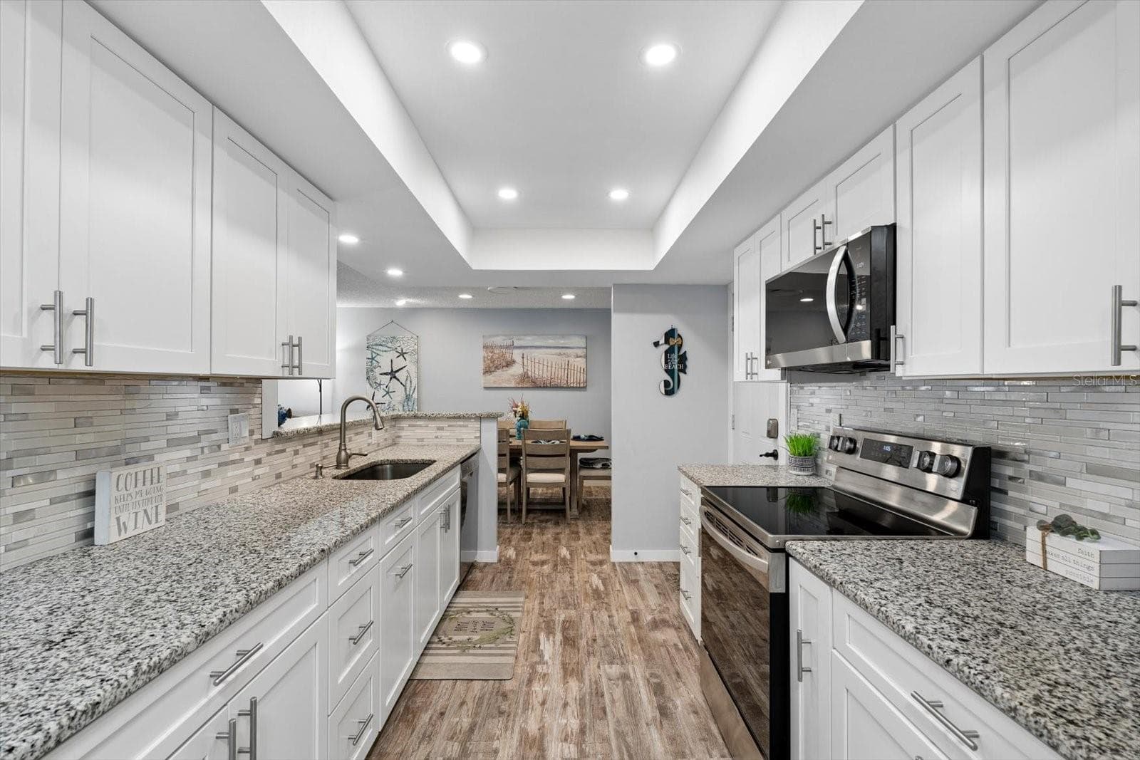 Gorgeous open kitchen with stainless steel appliances, white shaker cabinets, granite countertops, recessed lighting. - 1307 STONEHAVEN LN, DUNEDIN