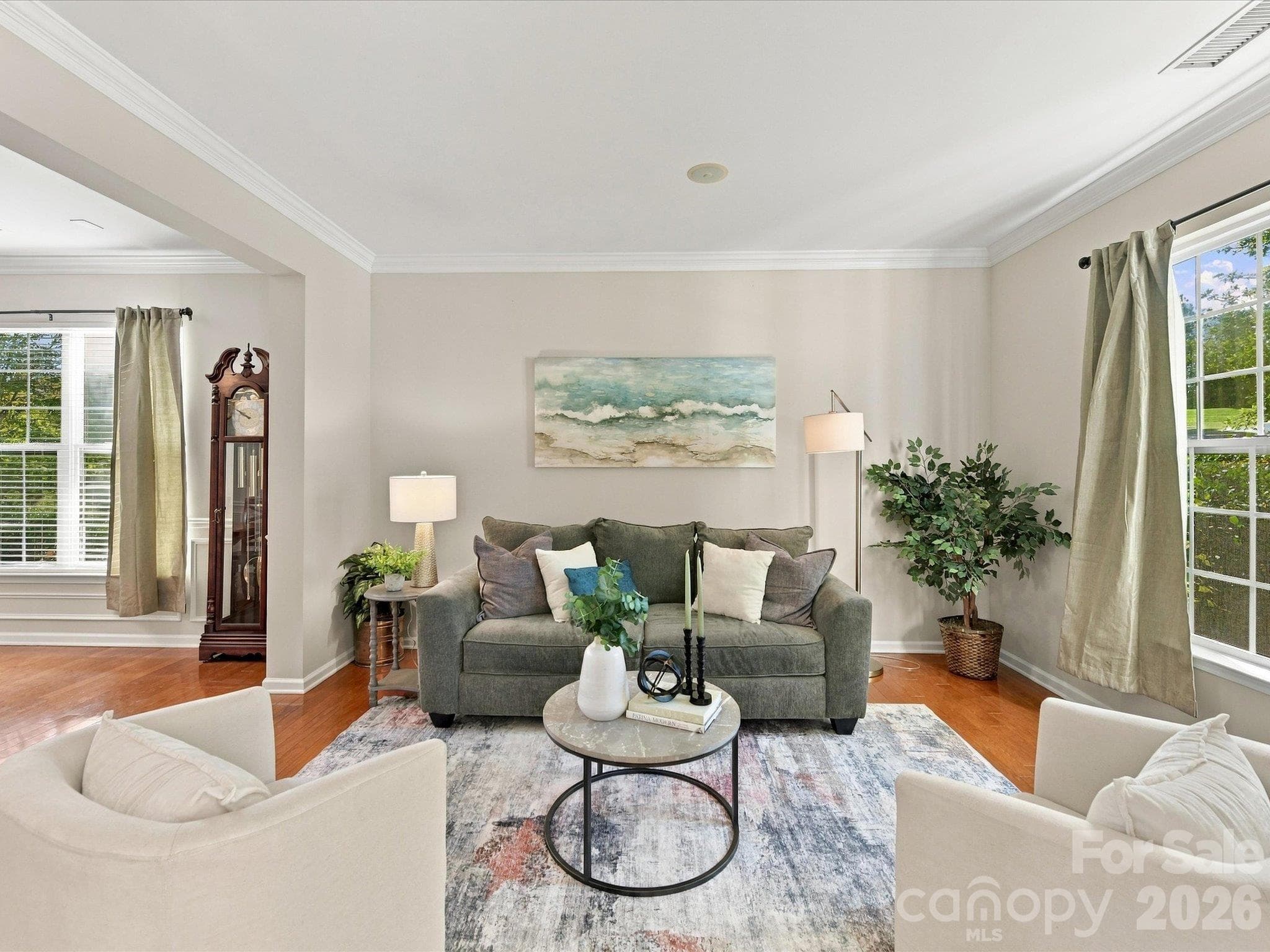 Spacious formal living room featuring rich hardwood floors, elegant crown molding, and an open layout that flows seamlessly into the main living areas, perfect for everyday living and entertaining. - 1788 Oakmont Drive, Denver
