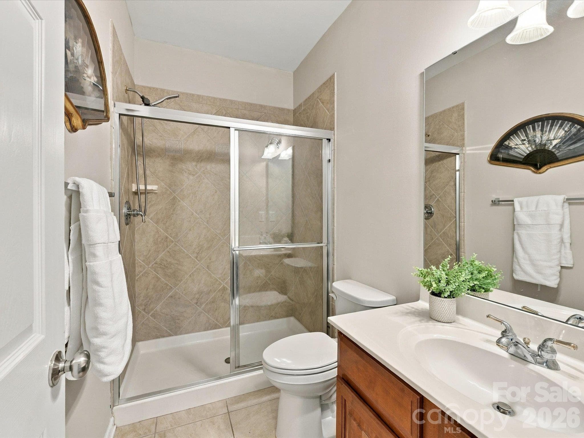 Main level full bathroom featuring a spacious vanity, tiled shower, and thoughtful finishes that provide comfort and functionality for family or guests. - 1788 Oakmont Drive, Denver