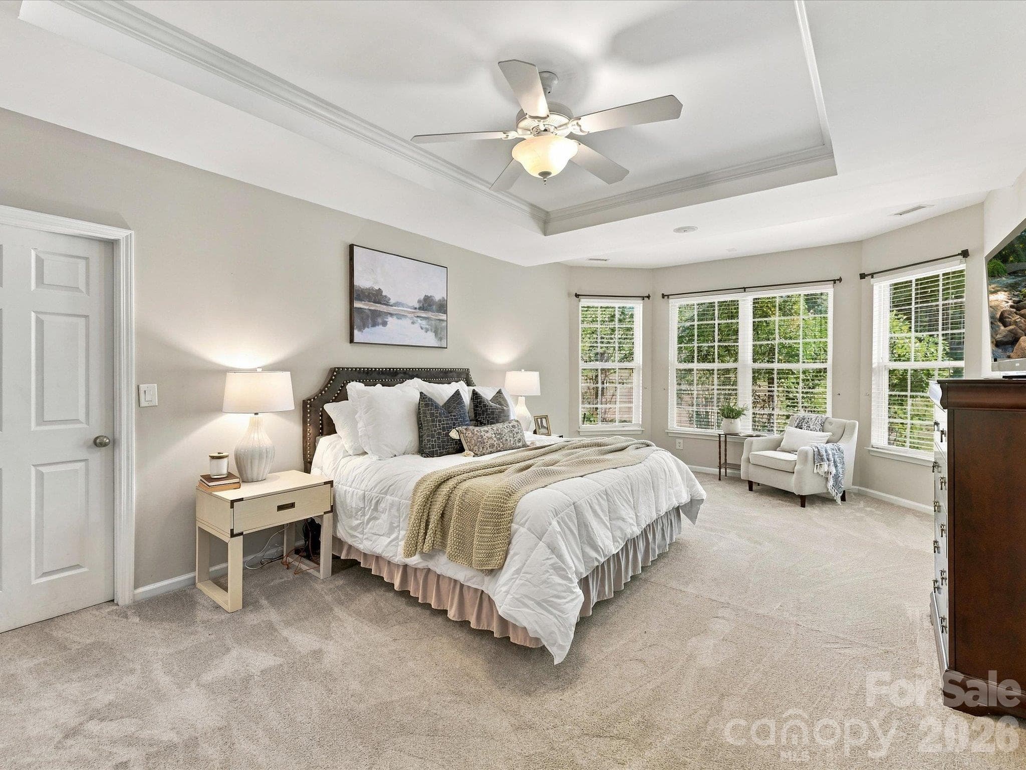 Spacious primary suite featuring a tray ceiling, abundant natural light, a cozy sitting area, and plenty of room to create your own private retreat. - 1788 Oakmont Drive, Denver