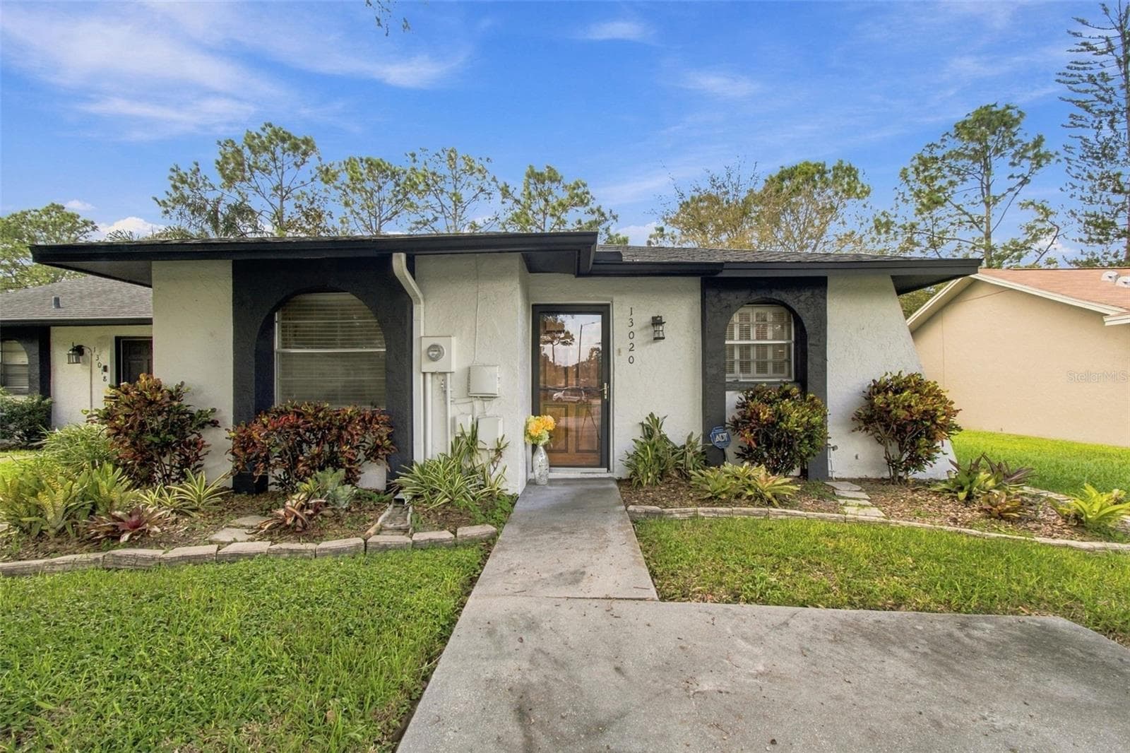Your well maintained home features a weather glass door and a solid wood front door. - 13020 LEVERINGTON ST, TAMPA