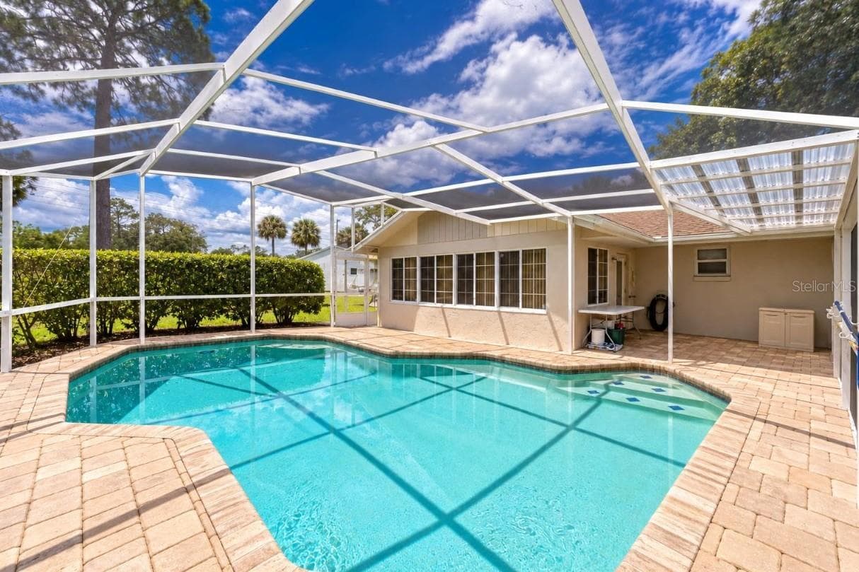 Spacious screened lanai showcasing an in-ground swimming pool, brick pavers, and direct access to the home. - 4669 SECRET RIVER TRL, PORT ORANGE