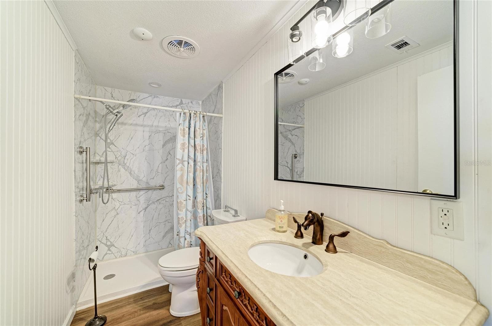 Bath 2/Hall bath has recently been updated with step-in shower with grab bars, a nice vanity and ligh fixture - 42 MEADOWLARK CIR, ELLENTON