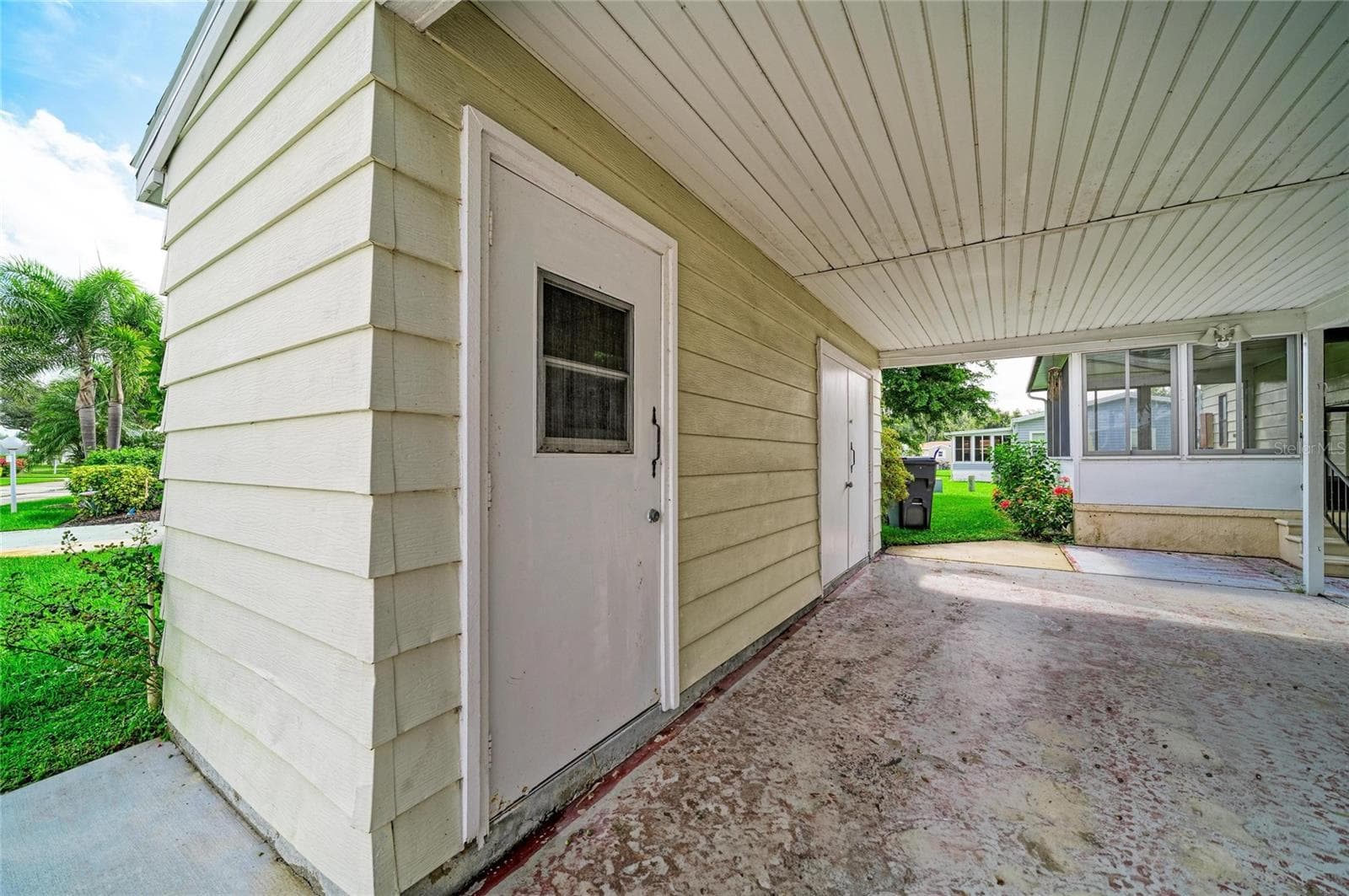 Covered carport with additional storage closet with utility sink - 42 MEADOWLARK CIR, ELLENTON