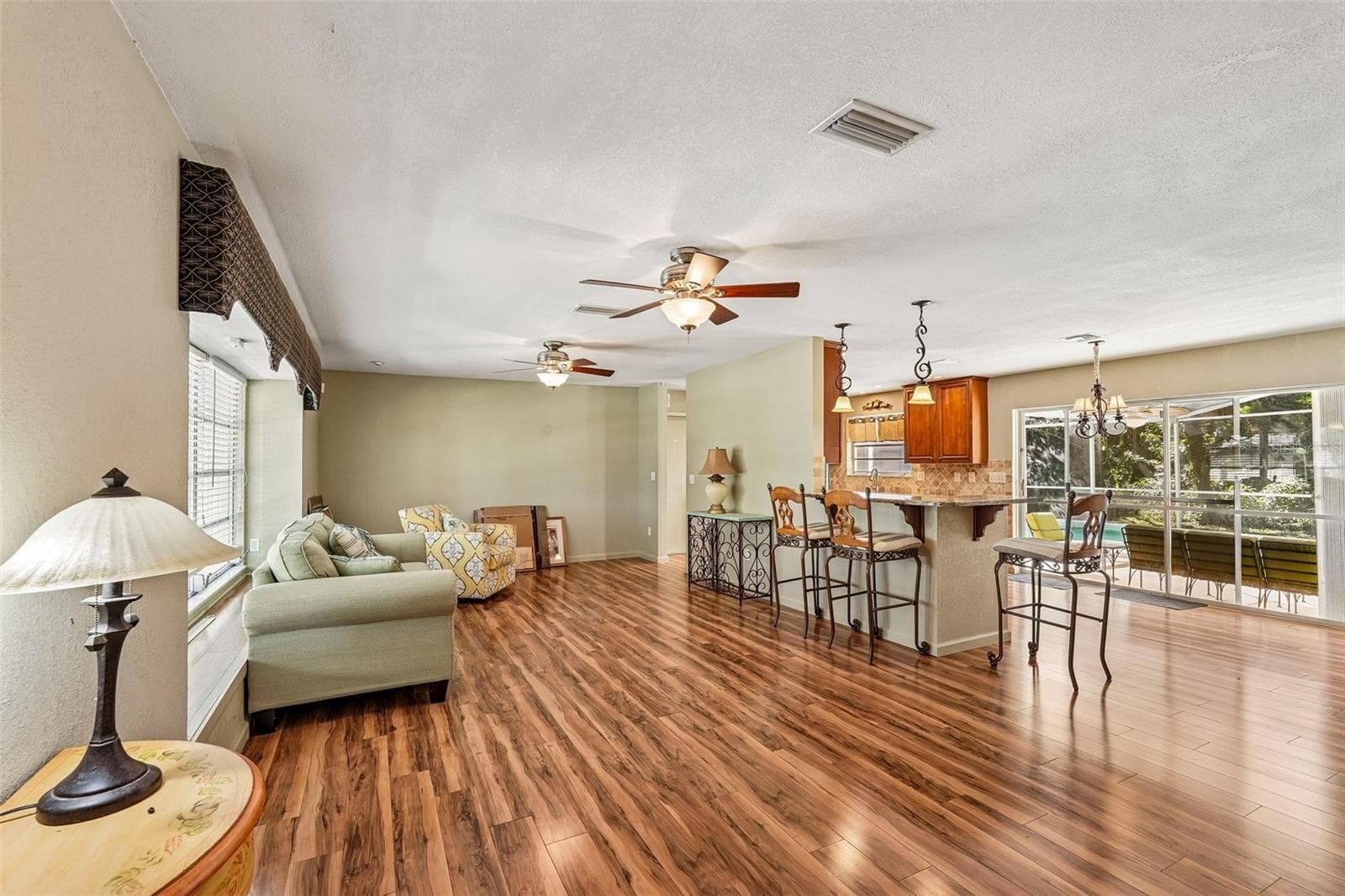 Living Room open to Dining room and kitchen with large lanai door out to pool - 22215 ONEIDA AVE, PORT CHARLOTTE