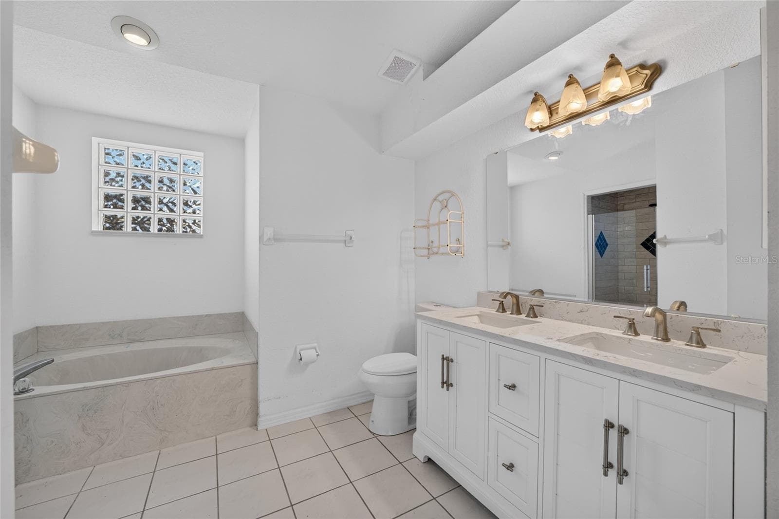Primary Bath with custom cabinetry and granite countertops - 7558 SW 103RD LOOP, OCALA
