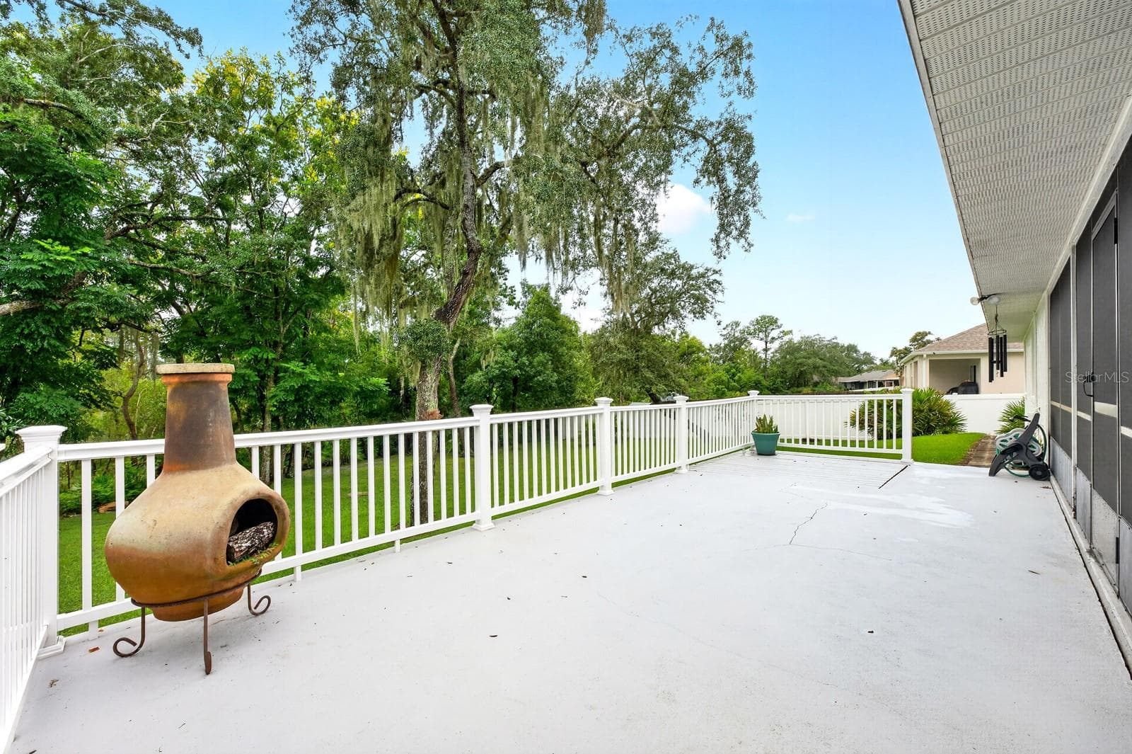 Step outside to the LARGE OPEN DECK overlooking the beautiful yard, where MATURE TREES create a lovely backdrop for outdoor enjoyment. - 2163 NEWMARK DR, DELTONA