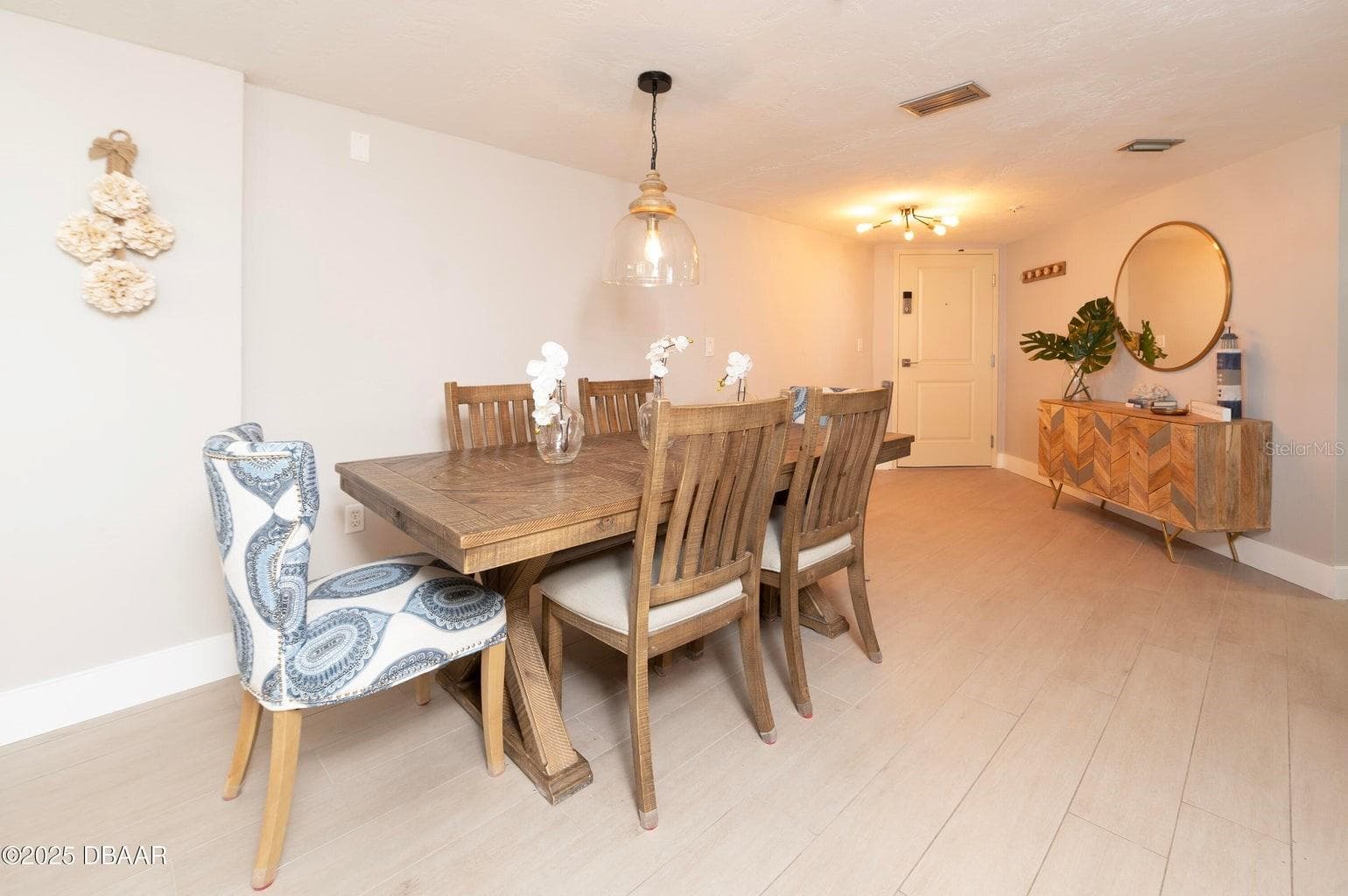 The spacious dining area offers an inviting setting for meals and entertaining, enhanced by contemporary pendant lighting and a seamless connection to the main living spaces. - 3855 S ATLANTIC AVE #401, DAYTONA BEACH