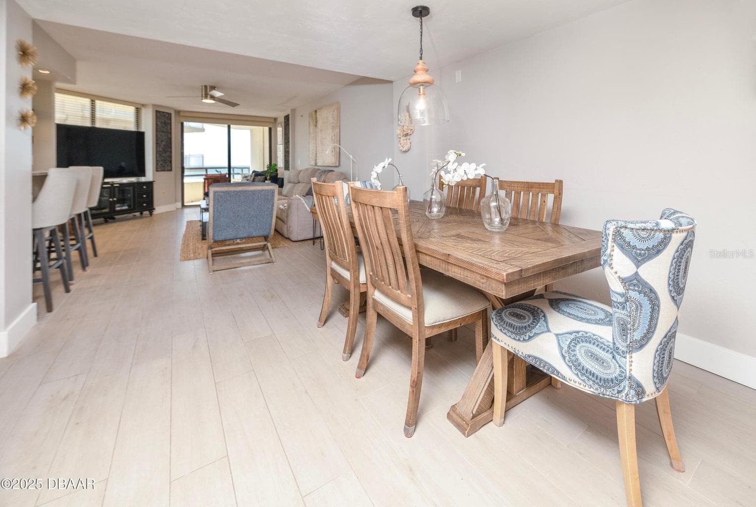 Enjoy an open, connected floor plan that brings together the dining room, kitchen, and living area. Neutral finishes and a direct view toward the oceanfront balcony enhance the relaxed coastal atmosphere. - 3855 S ATLANTIC AVE #401, DAYTONA BEACH