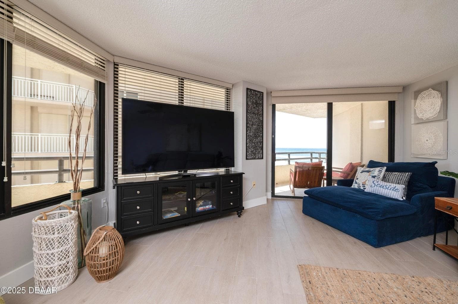 This bright and inviting living room features expansive windows and sliding glass doors opening to the private balcony, where beautiful Atlantic Ocean views await. - 3855 S ATLANTIC AVE #401, DAYTONA BEACH