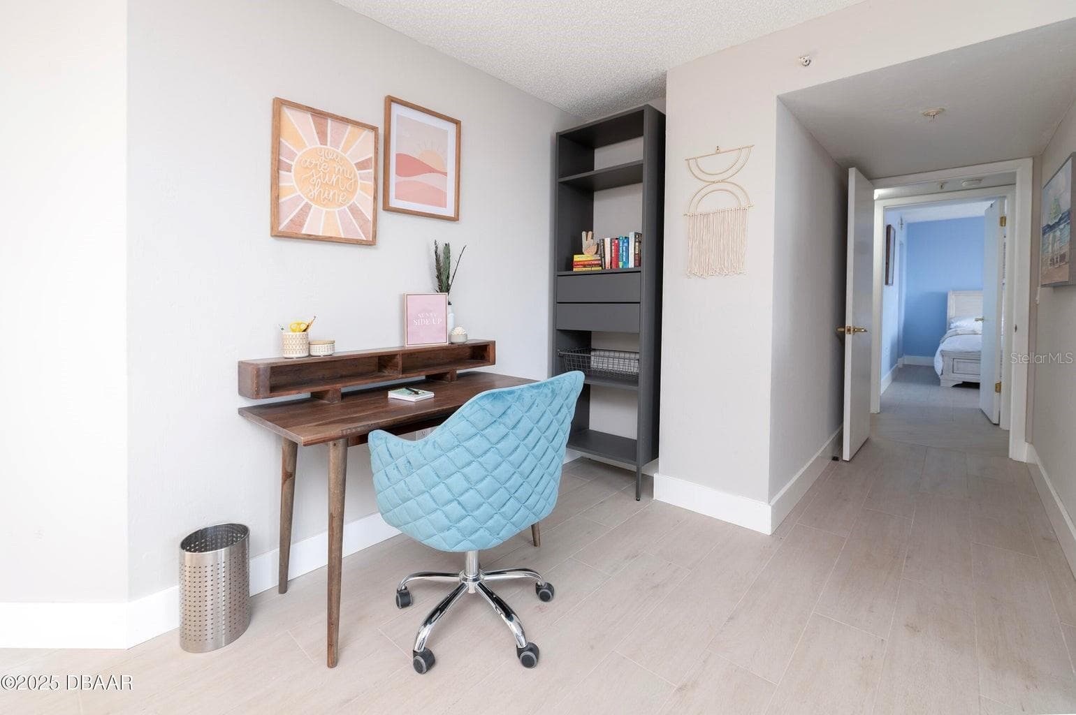A convenient workspace within the primary suite offers room for a desk and shelving, providing a functional area for remote work, reading, or organizing daily essentials. - 3855 S ATLANTIC AVE #401, DAYTONA BEACH