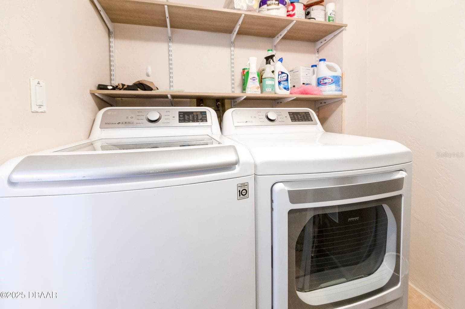 : Enjoy the convenience of a dedicated laundry area featuring a full-size washer and dryer, along with overhead shelving for organized storage of laundry essentials. - 3855 S ATLANTIC AVE #401, DAYTONA BEACH