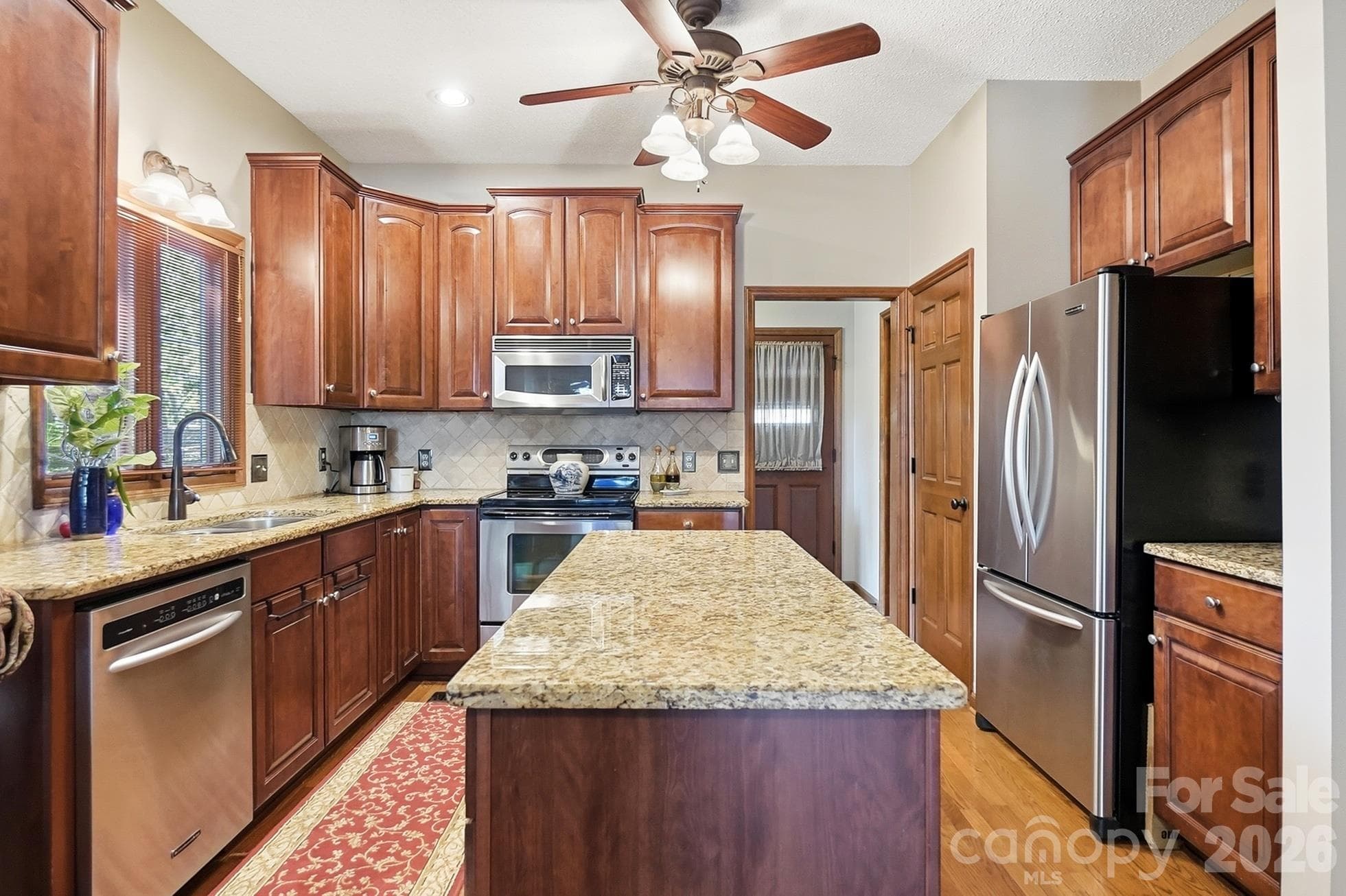 Kitchen with center island, granite counters, SS appliances, and compactor - 1669 Aragon Beach Road, Rock Hill