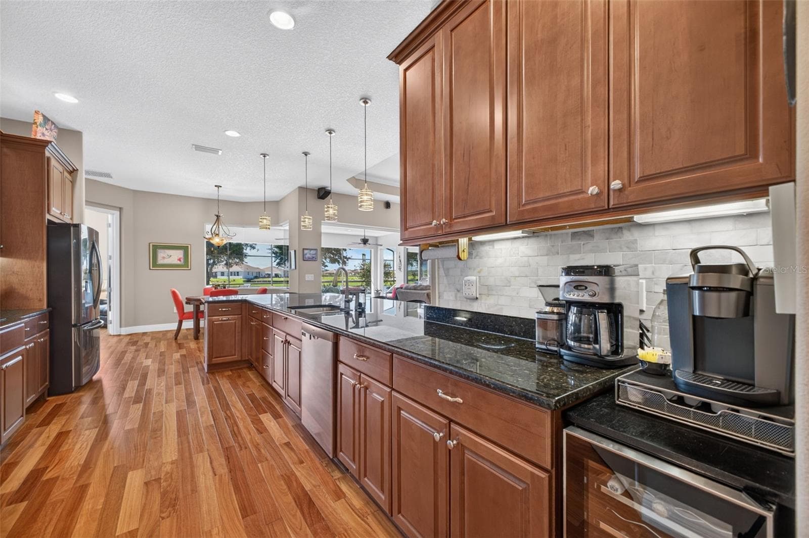 Under-cabinet lighting adds both warm atmosphere and practical task illumination to the workspace. - 2444 PAWTUCKET PASS, MOUNT DORA