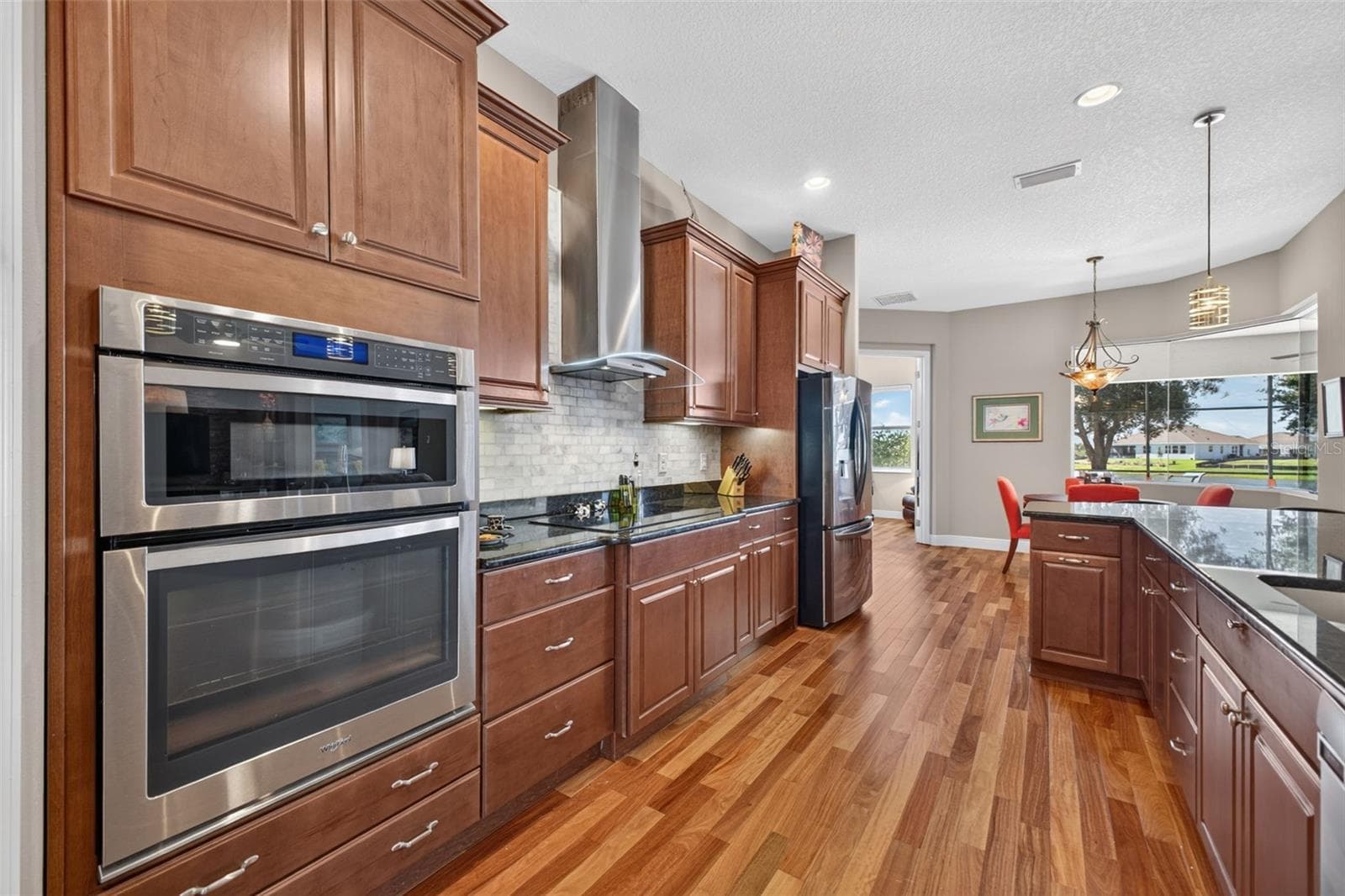 Equipped with a sleek induction cooktop paired with a stylish, exterior-vented range hood for optimal ventilation. - 2444 PAWTUCKET PASS, MOUNT DORA