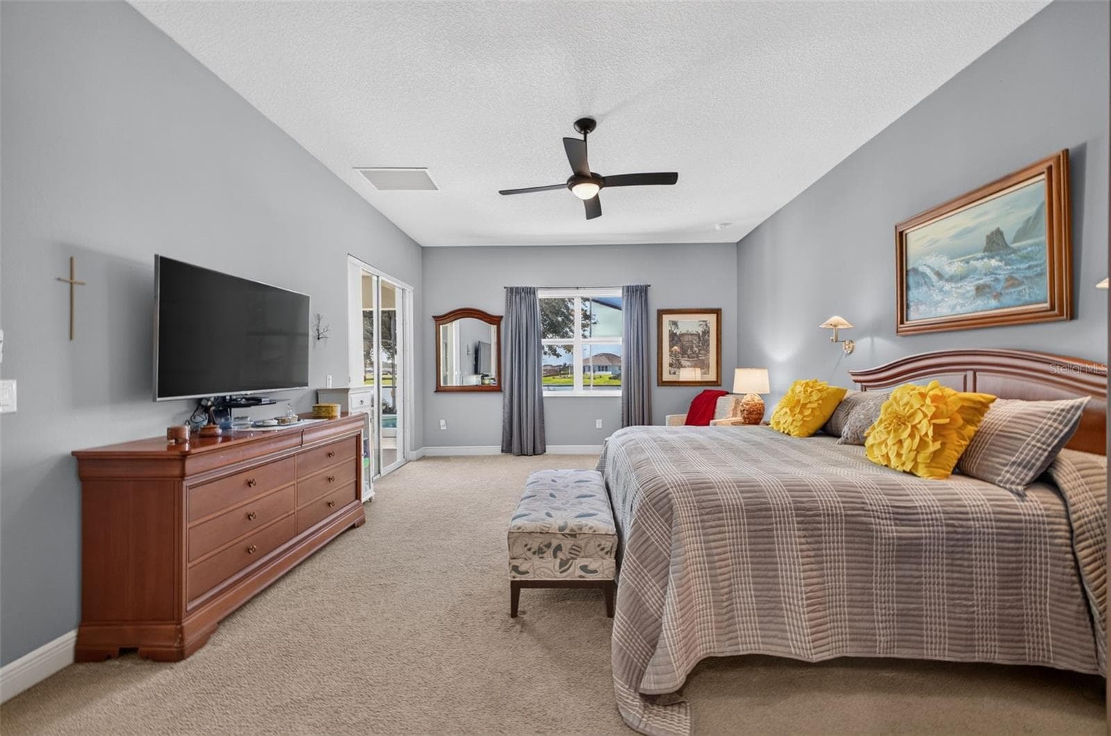 Positioned at the back of the home to capture sweeping lake views, this expansive primary retreat offers seamless indoor-outdoor flow to the pool and lanai. - 2444 PAWTUCKET PASS, MOUNT DORA