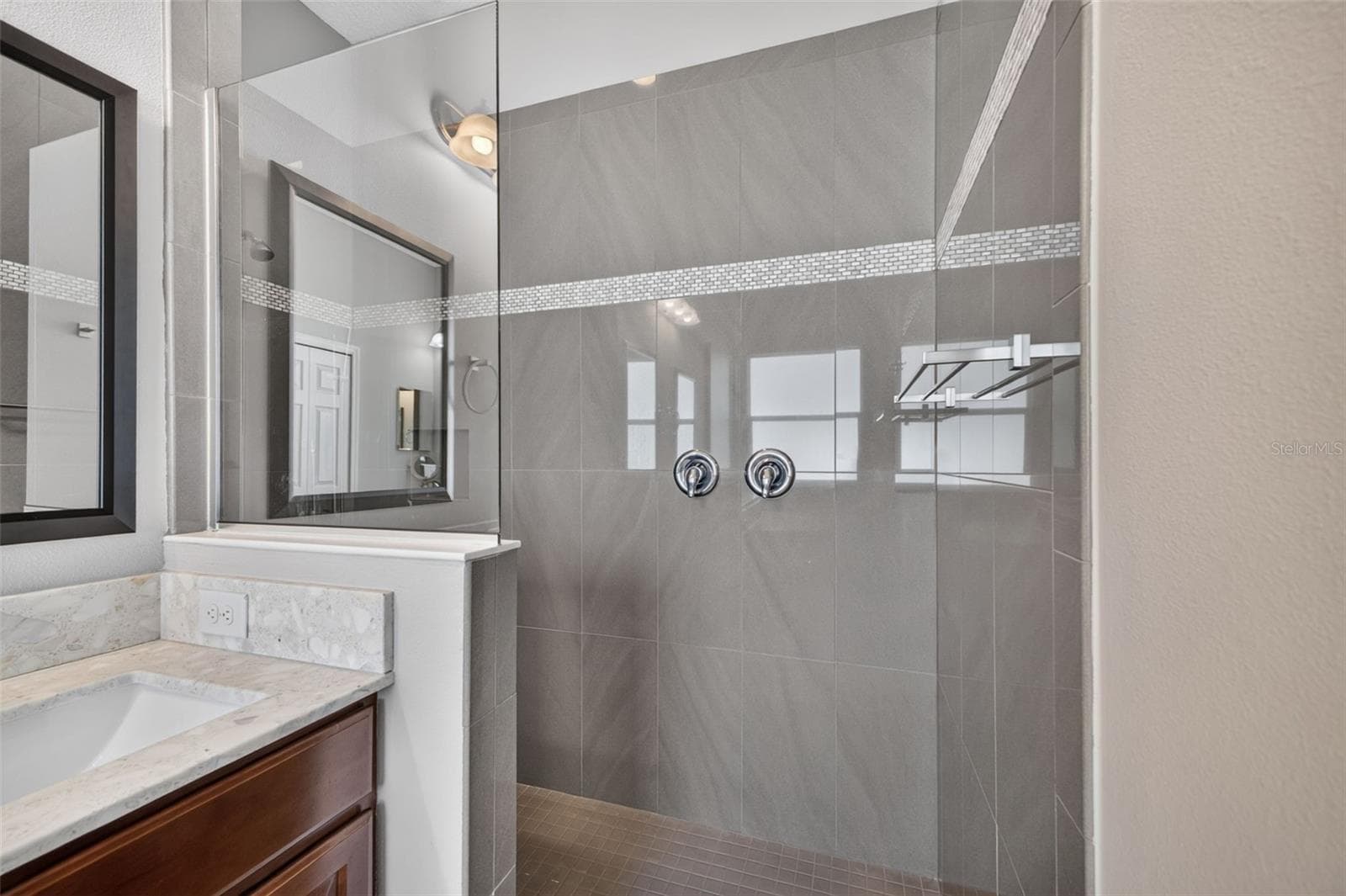 A separate, oversized walk-in shower features elegant tilework, offering a luxurious spa-like experience. - 2444 PAWTUCKET PASS, MOUNT DORA