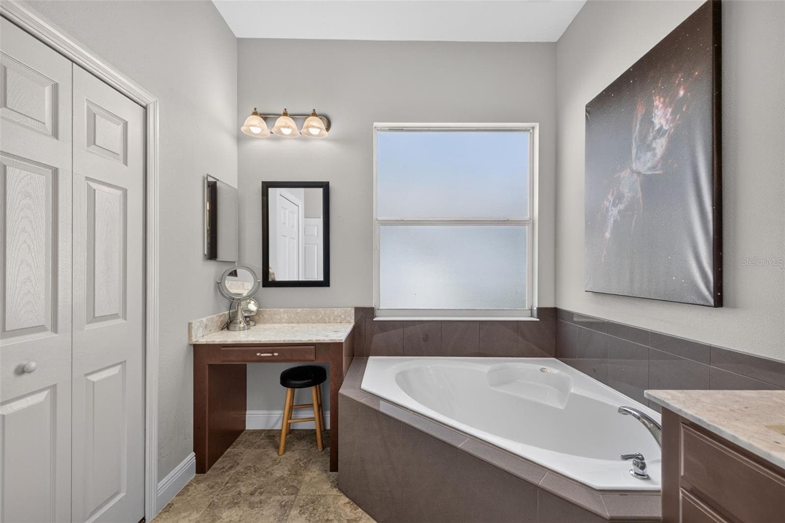 Pamper yourself in an elegant primary bath complete with a built-in makeup vanity and ample closet storage. - 2444 PAWTUCKET PASS, MOUNT DORA