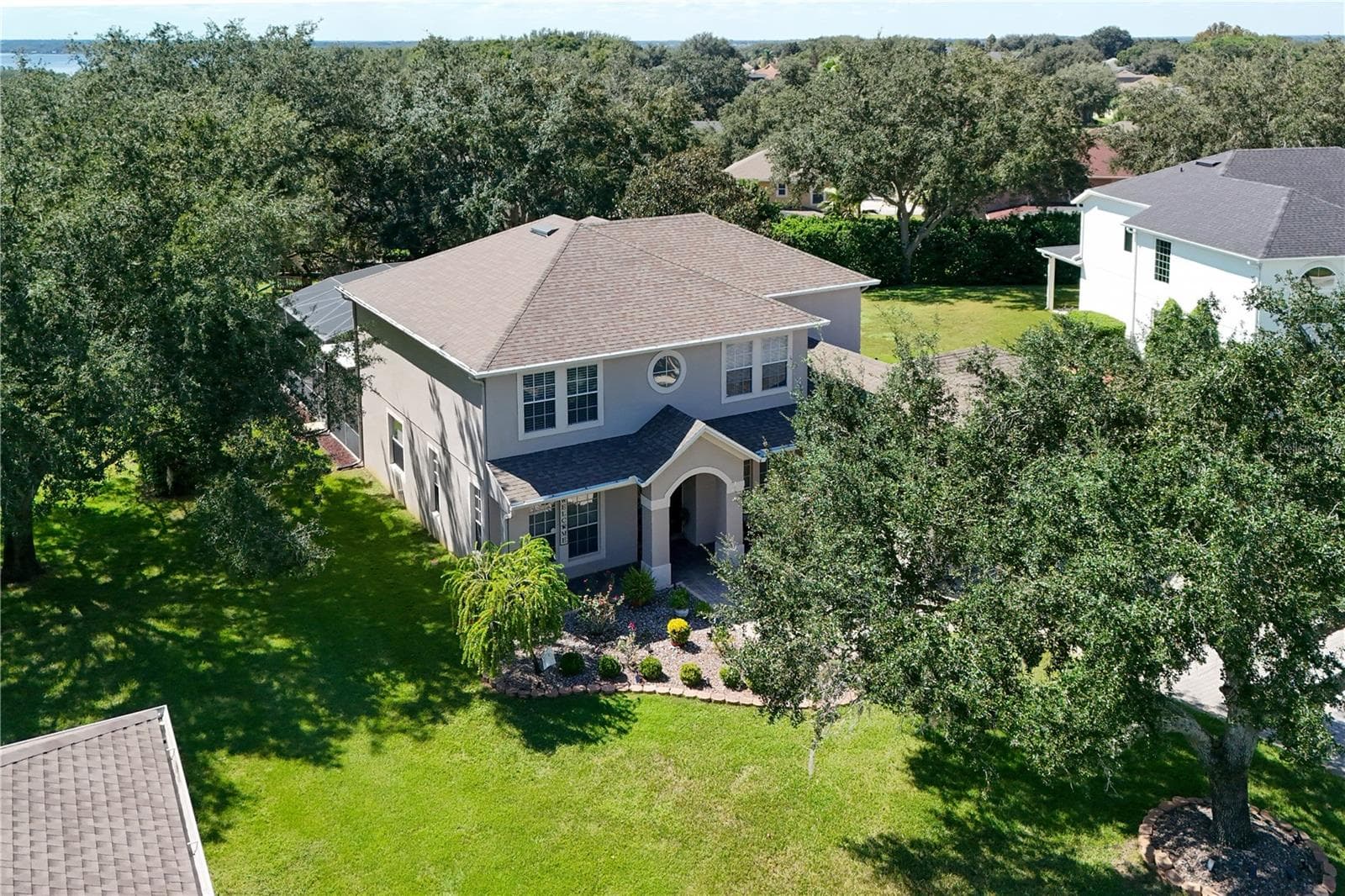 Beautifully landscaped grounds with mature magnolia trees - 4079 GREYSTONE DR, CLERMONT