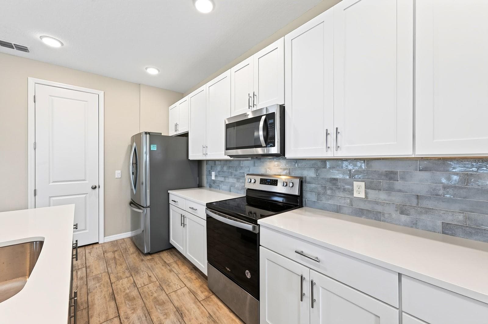 Beautiful WHITE cabinets and a greyish/blue subway tile backsplash - 880 LIVESTOCK LOOP, ST CLOUD
