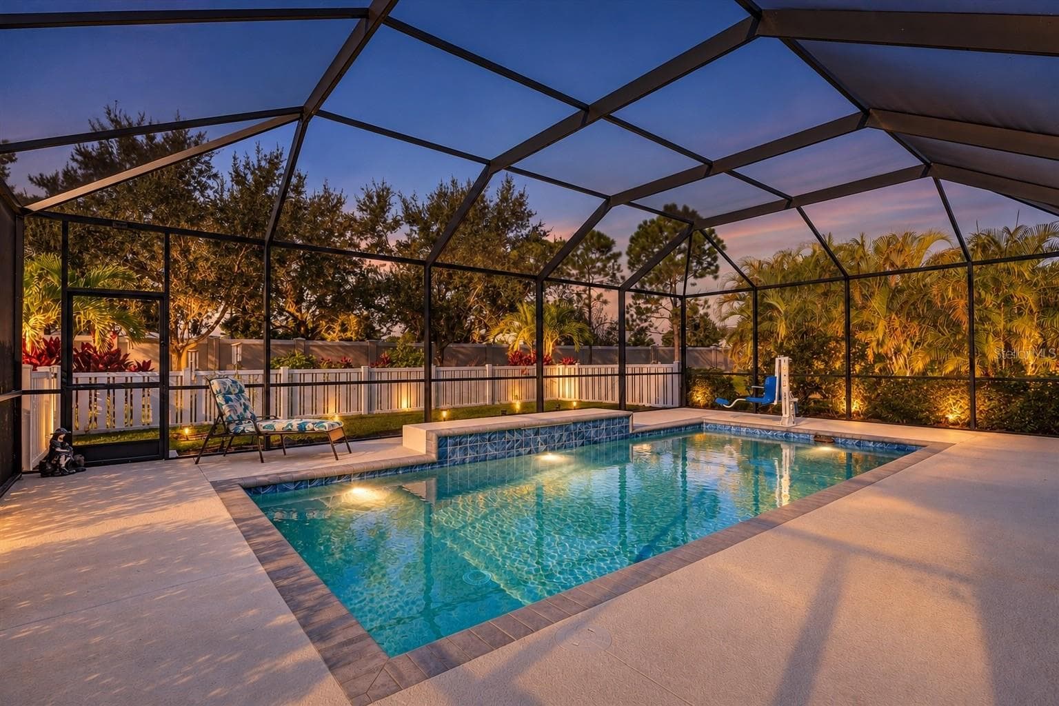 Pool View Looking West at Sunset. Staged Landscape Led Lighting - 7040 WHITE WILLOW CT, SARASOTA