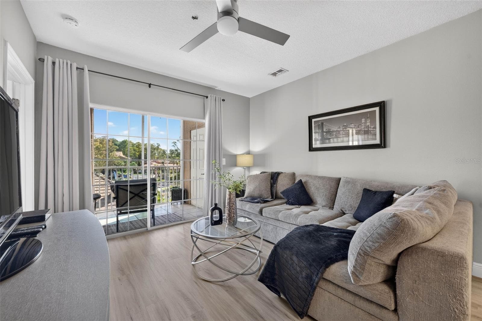 Living room sectional and sliding door to balcony - 4849 CYPRESS WOODS DR #1302, ORLANDO