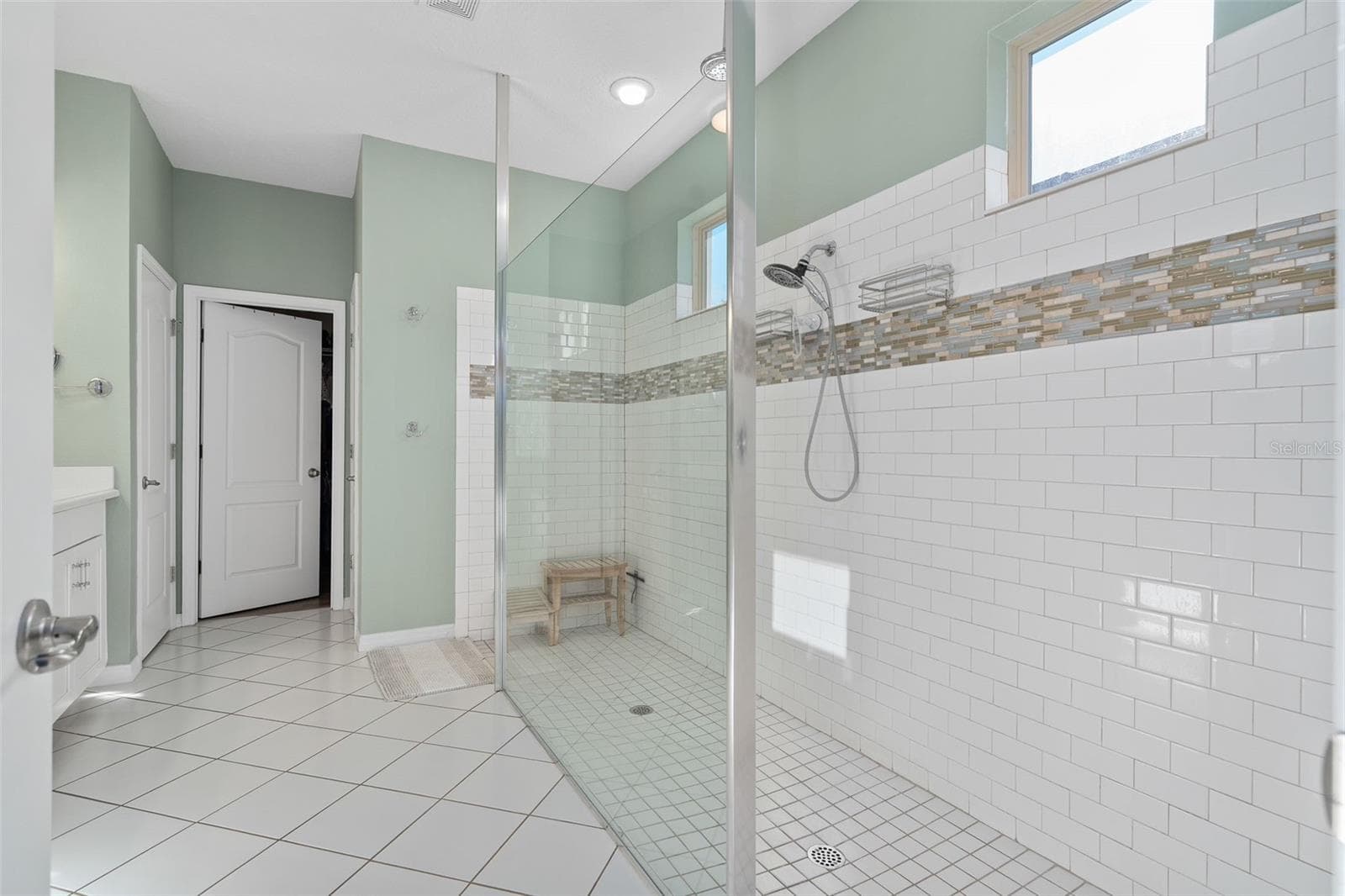Primary En-Suite Shower with a hand held sprayer and a Rain Shower. The Subway tile is accented with a beautiful Listello - 1038 TIMBERVALE TRL, CLERMONT