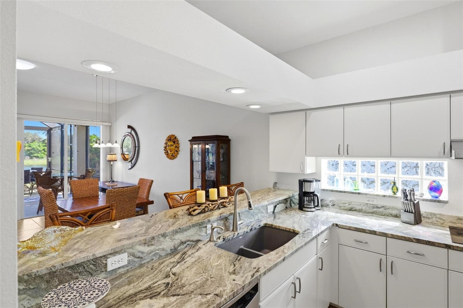 Kitchen and breakfast bar open to dining and living areas - 687 LAKESCENE DR, VENICE