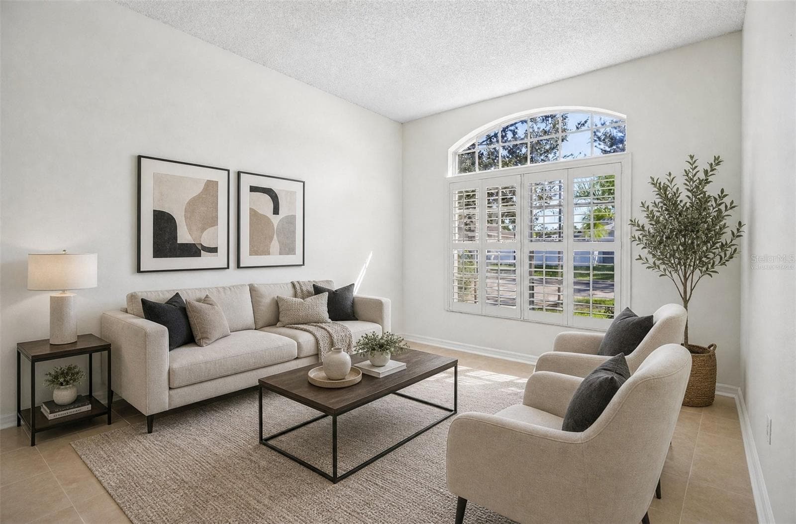 The formal Living Room greets you with an ELEGANT ARCHED-TOPPED WINDOW fitted with plantation shutters. Virtually Staged - 1806 ANNA CATHERINE DR, ORLANDO