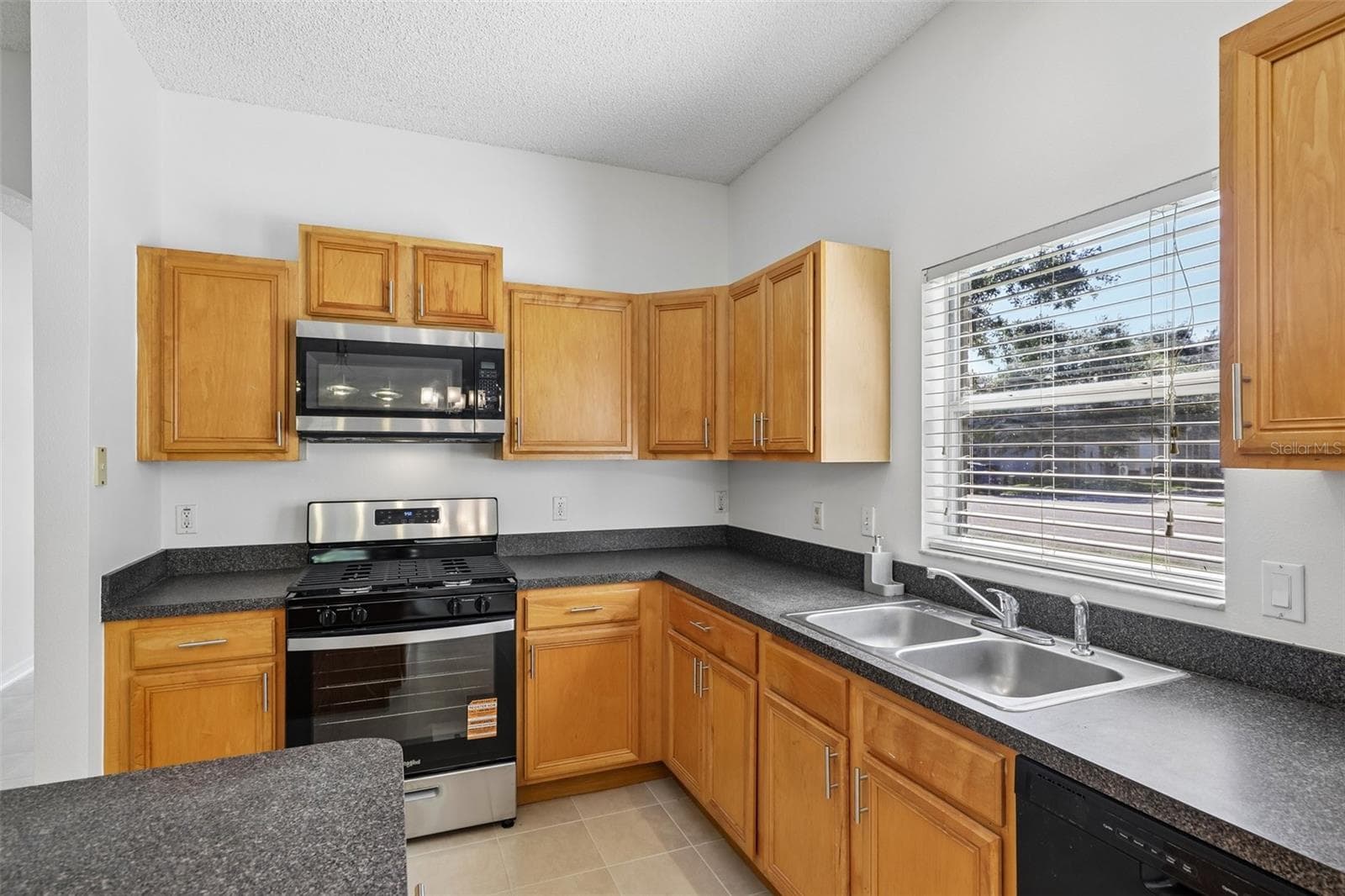 The SPACIOUS KITCHEN features abundant cabinetry and counter space, a gas stove, center island and convenient closet pantry. - 1806 ANNA CATHERINE DR, ORLANDO