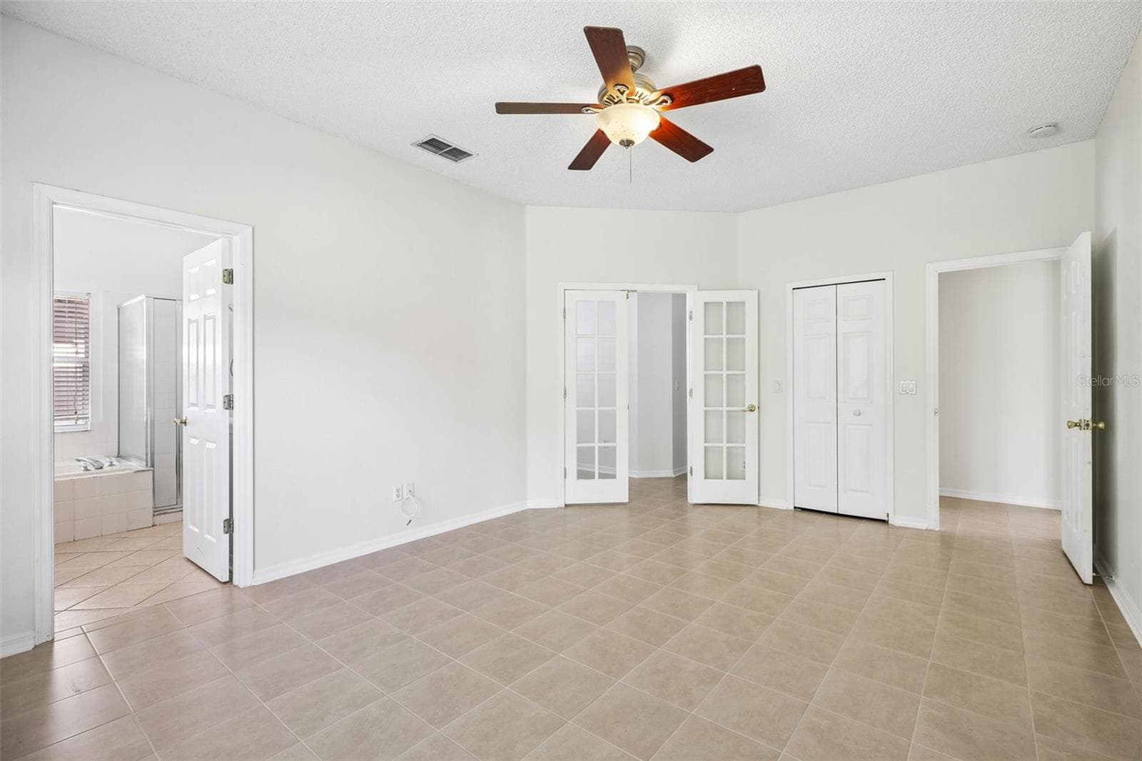 An especially VERSATILE FEATURE of the Primary Bedroom is the set of glass-paneled French doors leading to a Bonus Room. - 1806 ANNA CATHERINE DR, ORLANDO