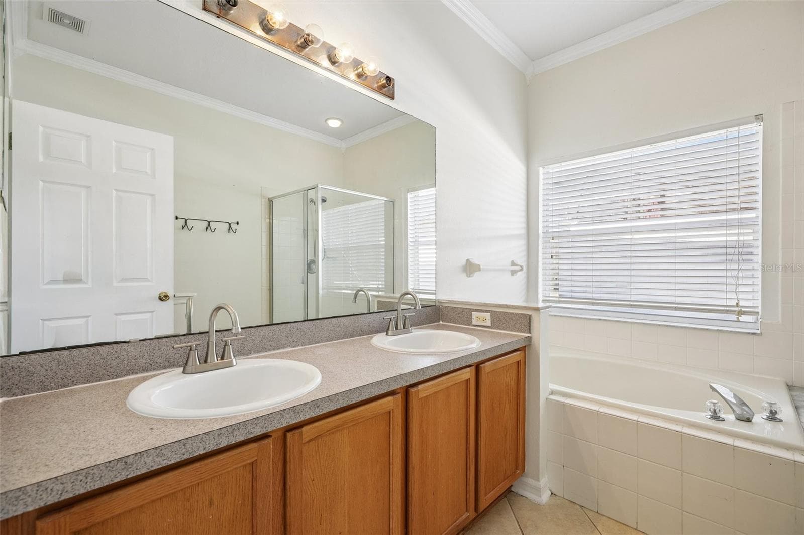 The Primary en suite Bath features dual sinks, a garden tub and a separate step-in shower. - 1806 ANNA CATHERINE DR, ORLANDO