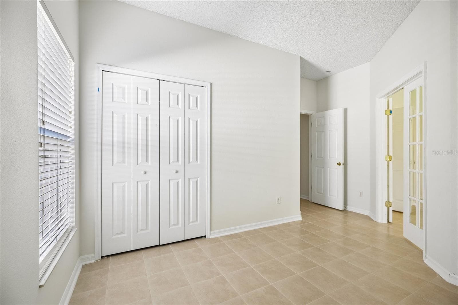 Glass-paneled French doors lead from the Primary Suite to a BONUS ROOM that could serve as a home office, nursery, hobby room, or POTENTIAL FOURTH BEDROOM, depending on your needs. - 1806 ANNA CATHERINE DR, ORLANDO