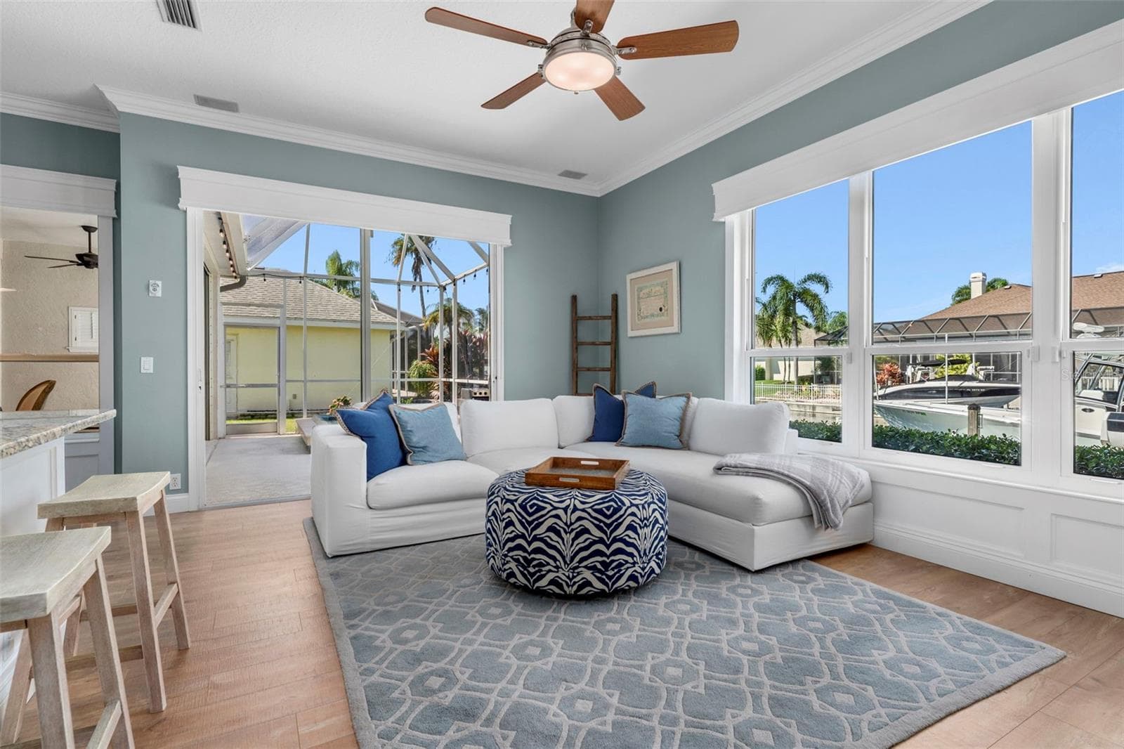 Generous windows frame the waterfront setting, while crown molding and warm flooring give the room a finished feel. - 4739 COMPASS DR, BRADENTON