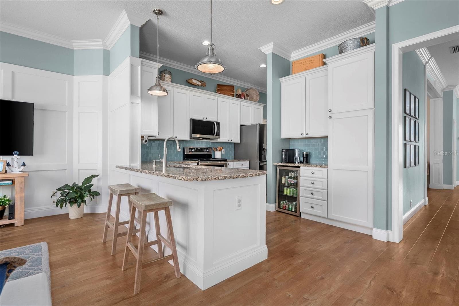 Tall cabinetry w/ built ins adds useful storage beside a cozy breakfast nook, with the dining room conveniently nearby. - 4739 COMPASS DR, BRADENTON