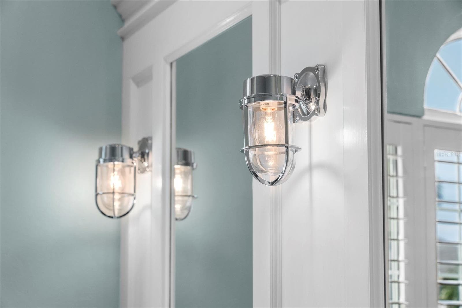 Nautical-inspired sconces and detailed mirror trim add character to the primary bath. - 4739 COMPASS DR, BRADENTON