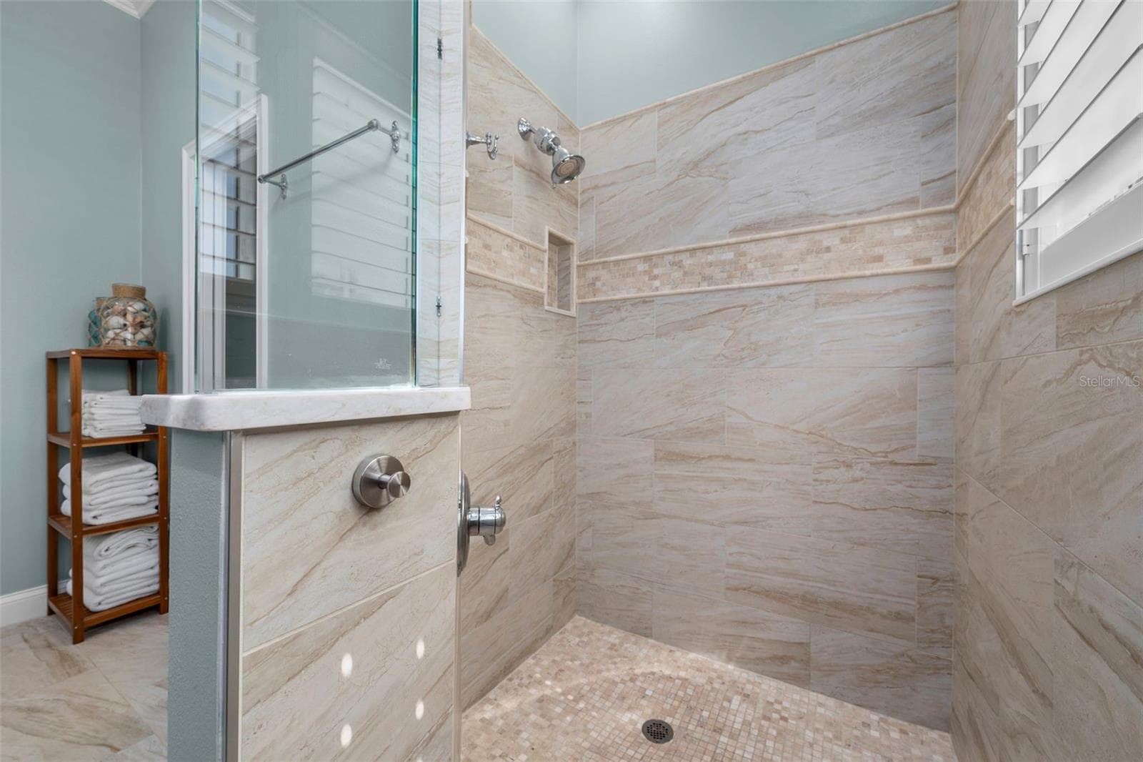 A spacious walk-in shower pairs warm tile tones with glass accents for a relaxing, spa-inspired feel. - 4739 COMPASS DR, BRADENTON