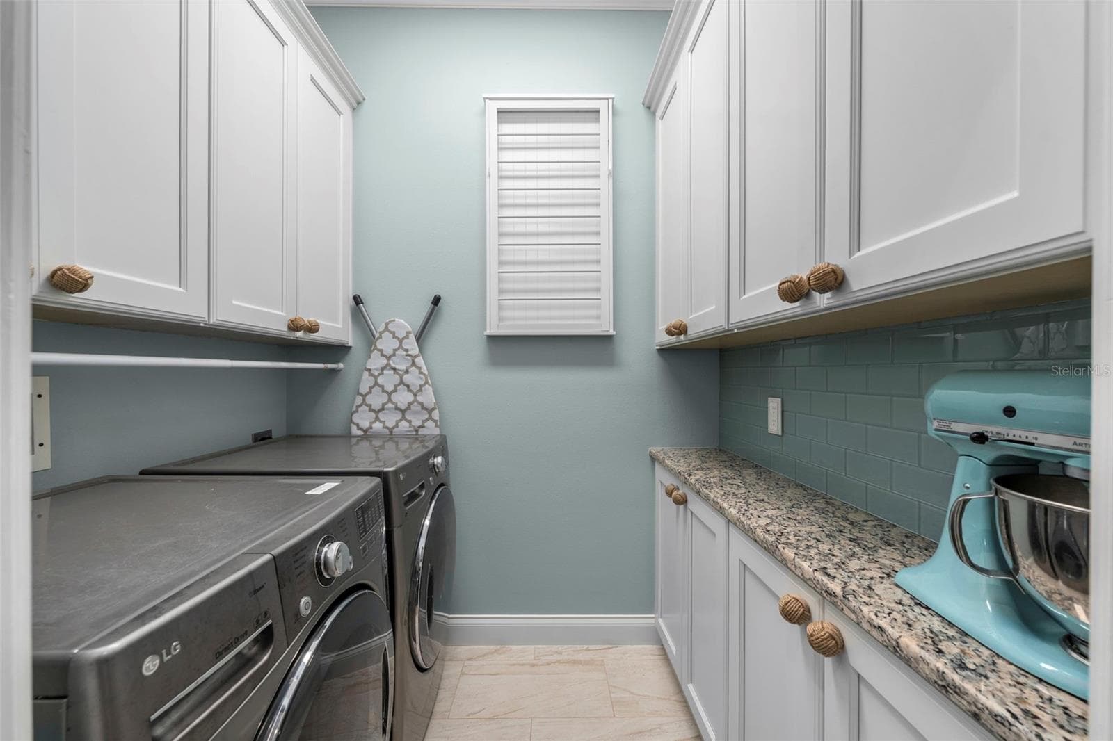 Generous cabinetry, granite counter space, and a coordinating tile backsplash make laundry day a little more enjoyable. - 4739 COMPASS DR, BRADENTON