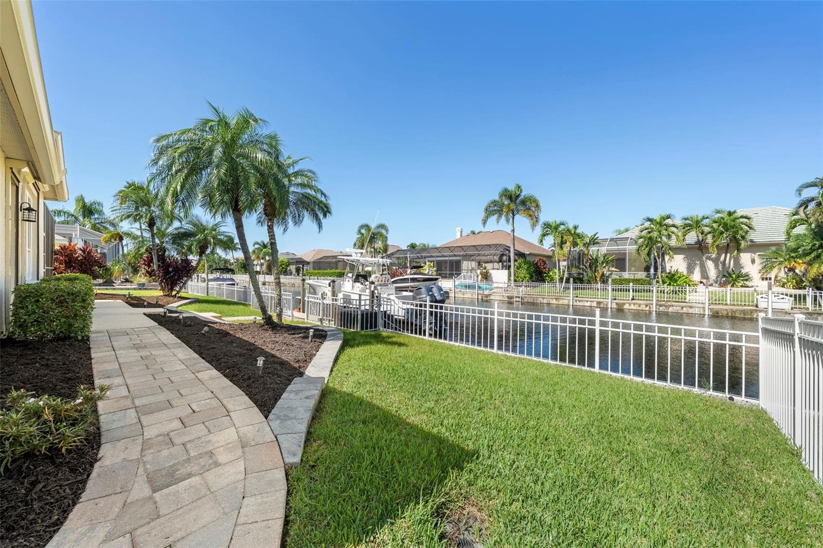 Step outside to tropical landscaping, canal views, and a convenient path to your private dock. - 4739 COMPASS DR, BRADENTON
