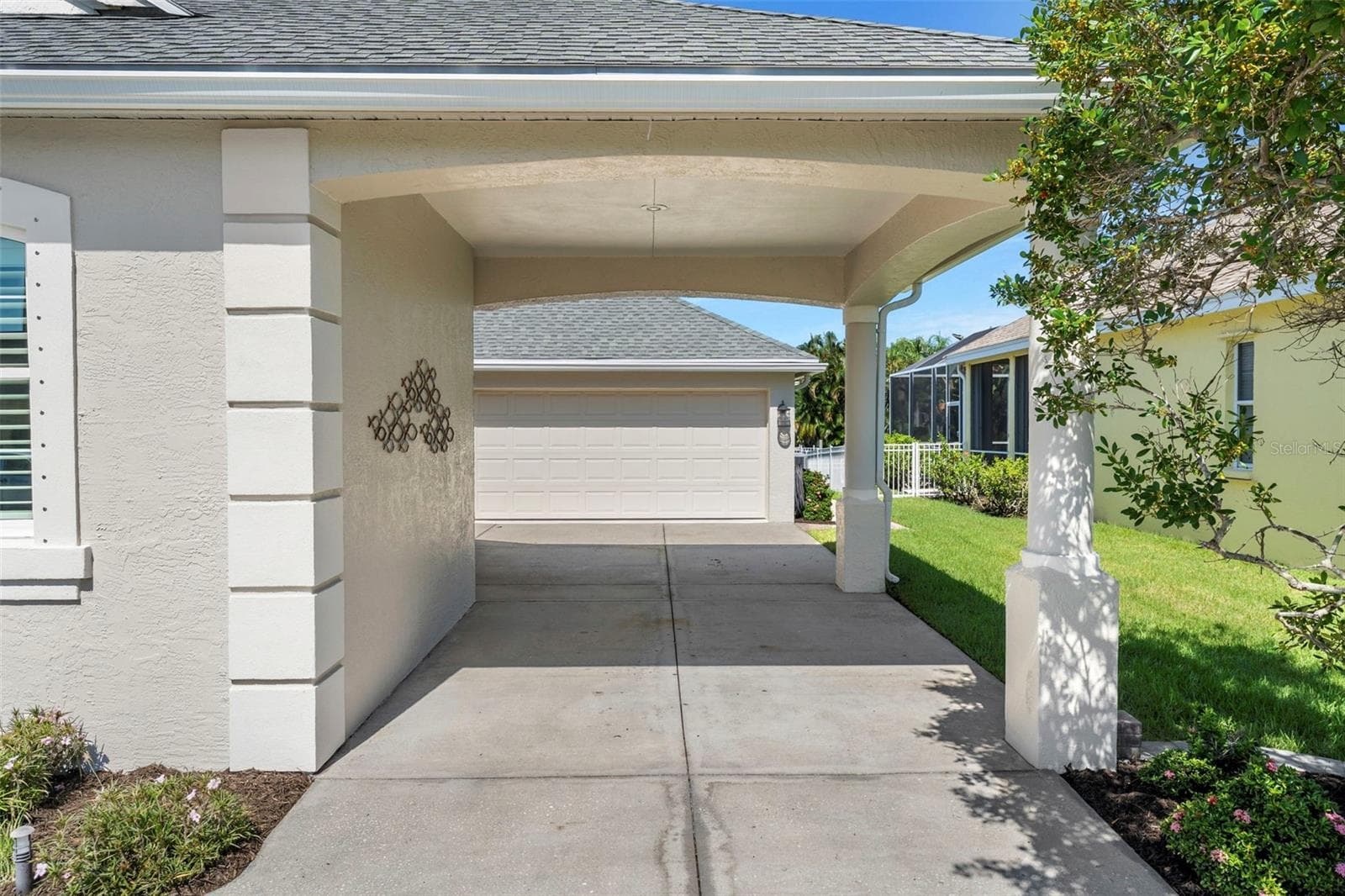 A welcoming covered entry sits beside the tandem garage, with extra room inside for storage and waterfront gear. - 4739 COMPASS DR, BRADENTON