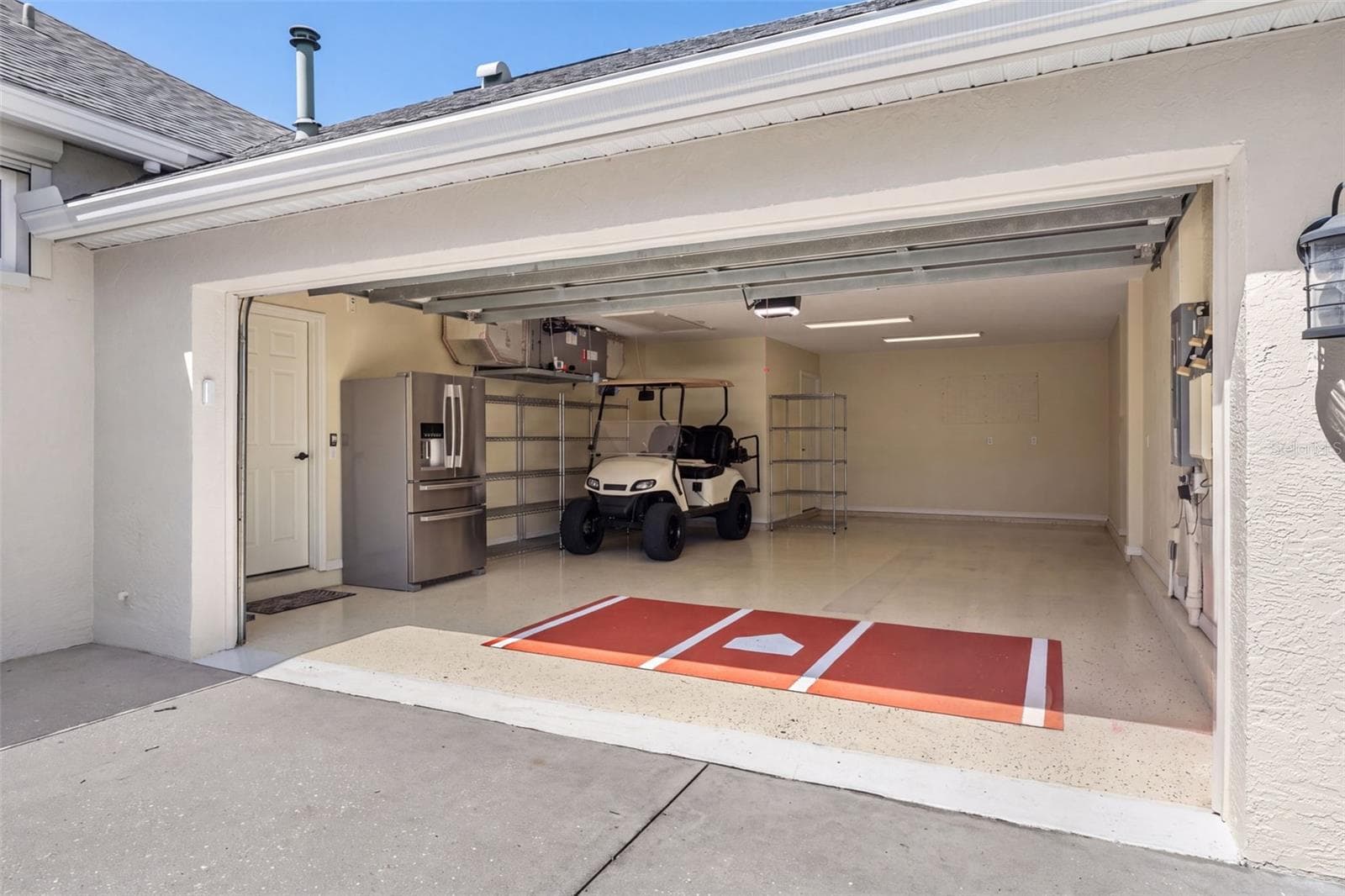 The spacious tandem garage features finished flooring and room for vehicles, a golf cart, storage, and boating essentials. - 4739 COMPASS DR, BRADENTON