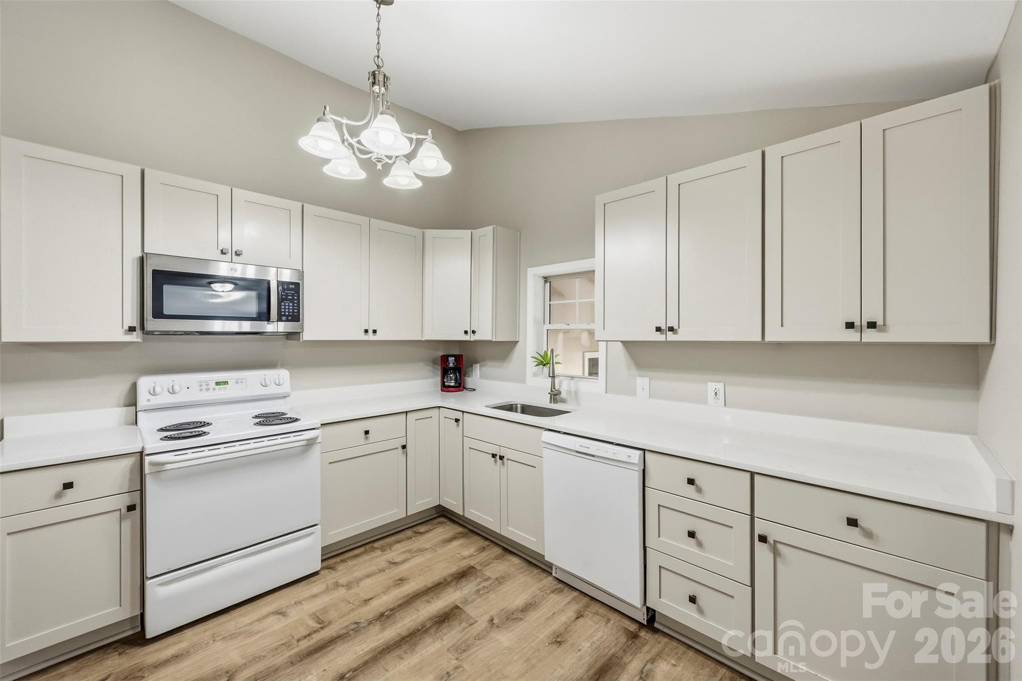 Kitchen (12'4" x 12'4") with white cabinets and a microwave over the range. - 220 Armour Street, Davidson