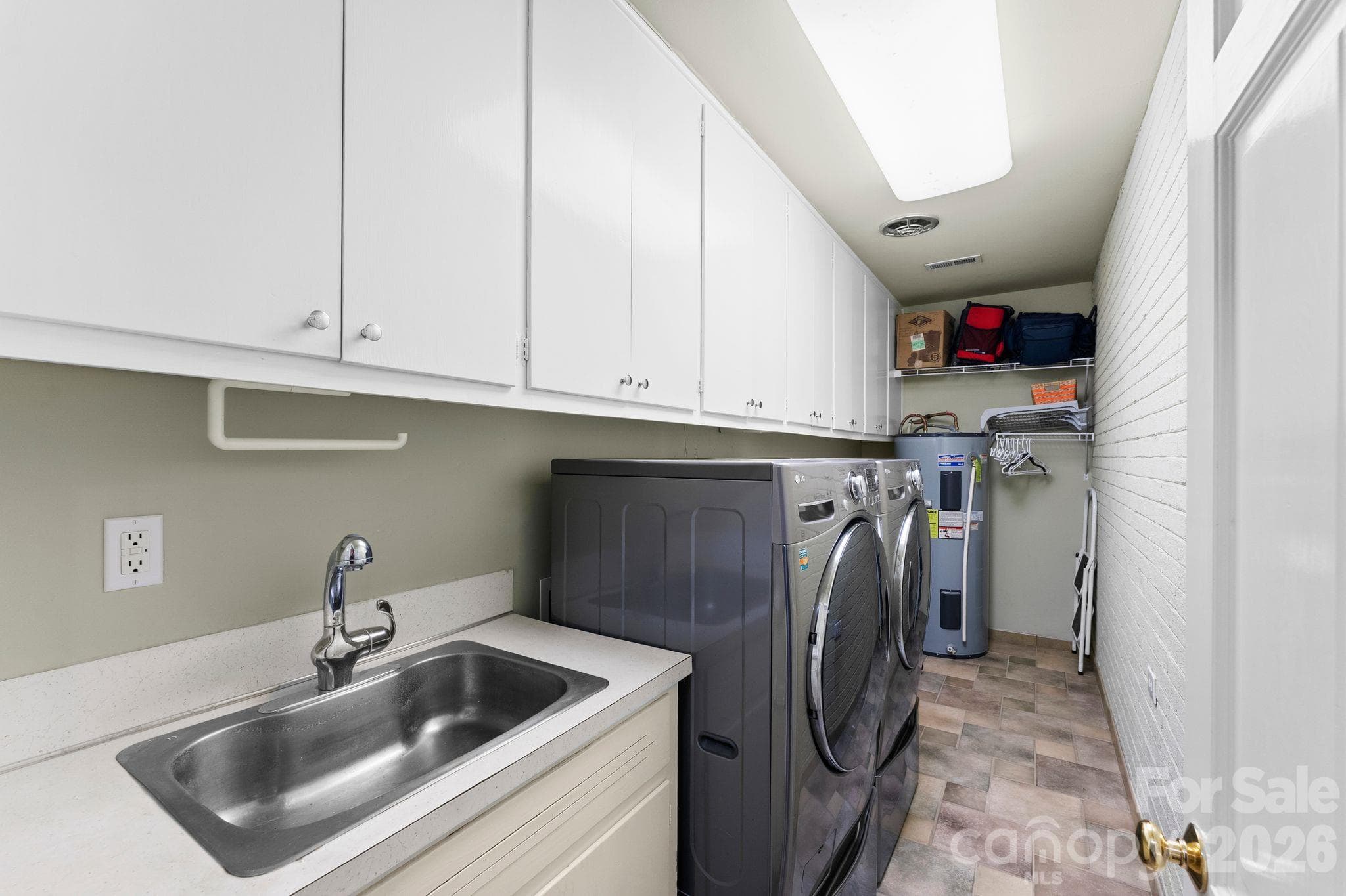 Laundry room with a utility sink and cabinetry for extra storage - 2006 Grey Road, Davidson