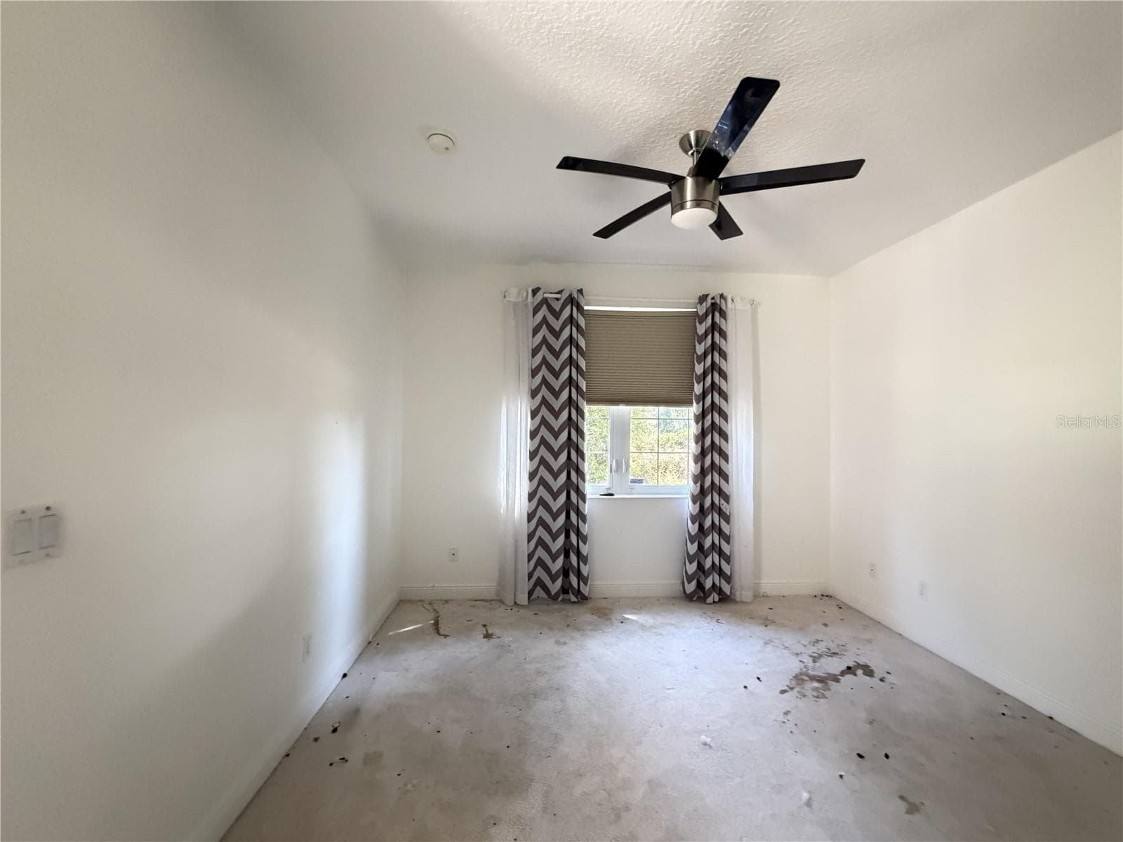 Secondary bedroom with ceiling fan, window, and heavily stained carpet. - 39539 HARBOR HILLS BLVD, LADY LAKE