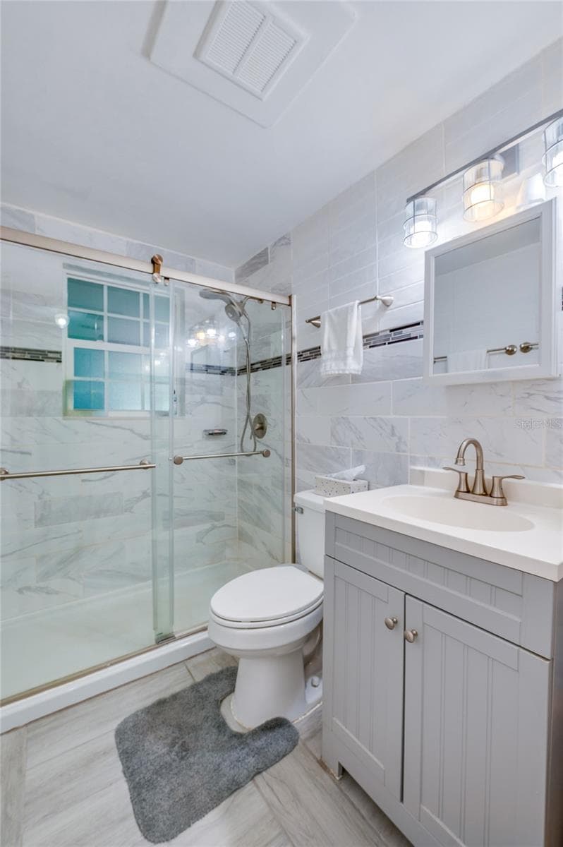 Remodeled bathroom with floor to ceiling tile - 300 ALICE ST, EDGEWATER